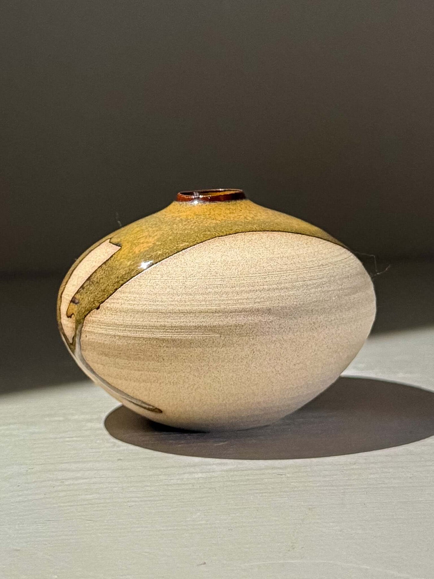 Orb Vase – Tenmoku #13, a handmade ceramic vase with a unique glaze design and soft spherical form.