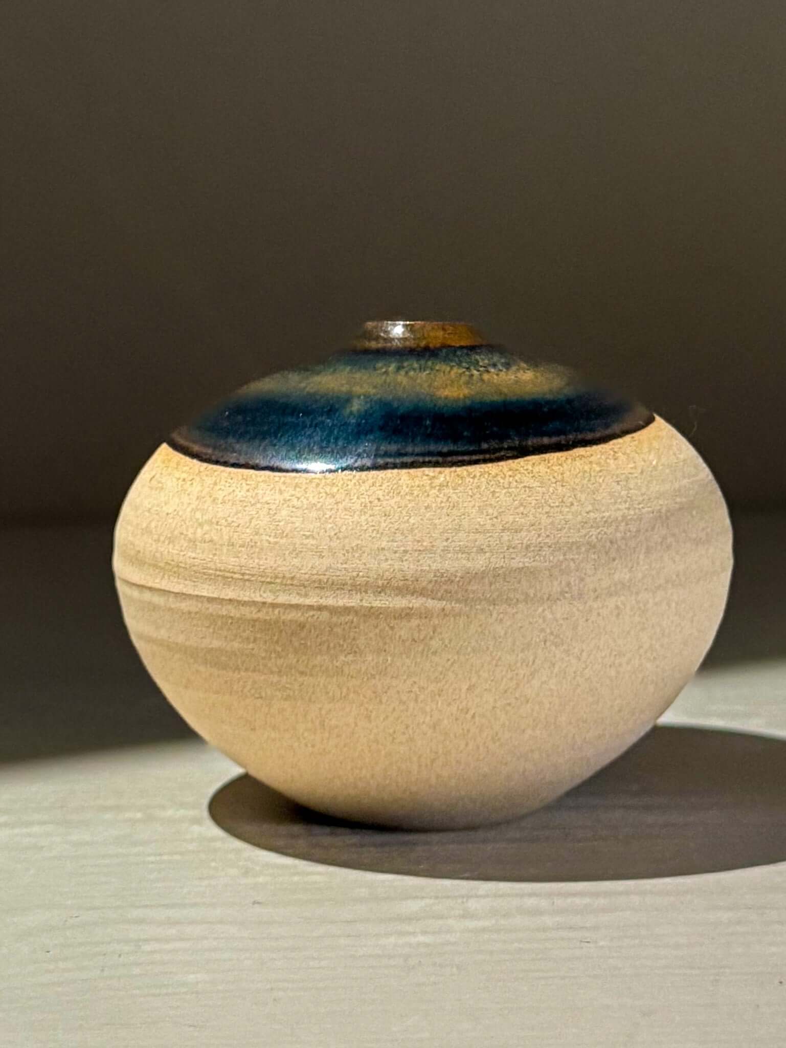 Orb Vase – Tenmoku #14 handmade ceramics with unique glaze patterns and a calming spherical design.