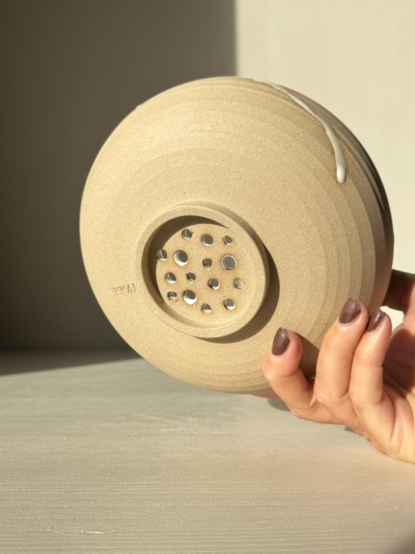 Underside of Rounded Berry Bowl - Yuki showing handmade holes for drainage in natural toffee clay.