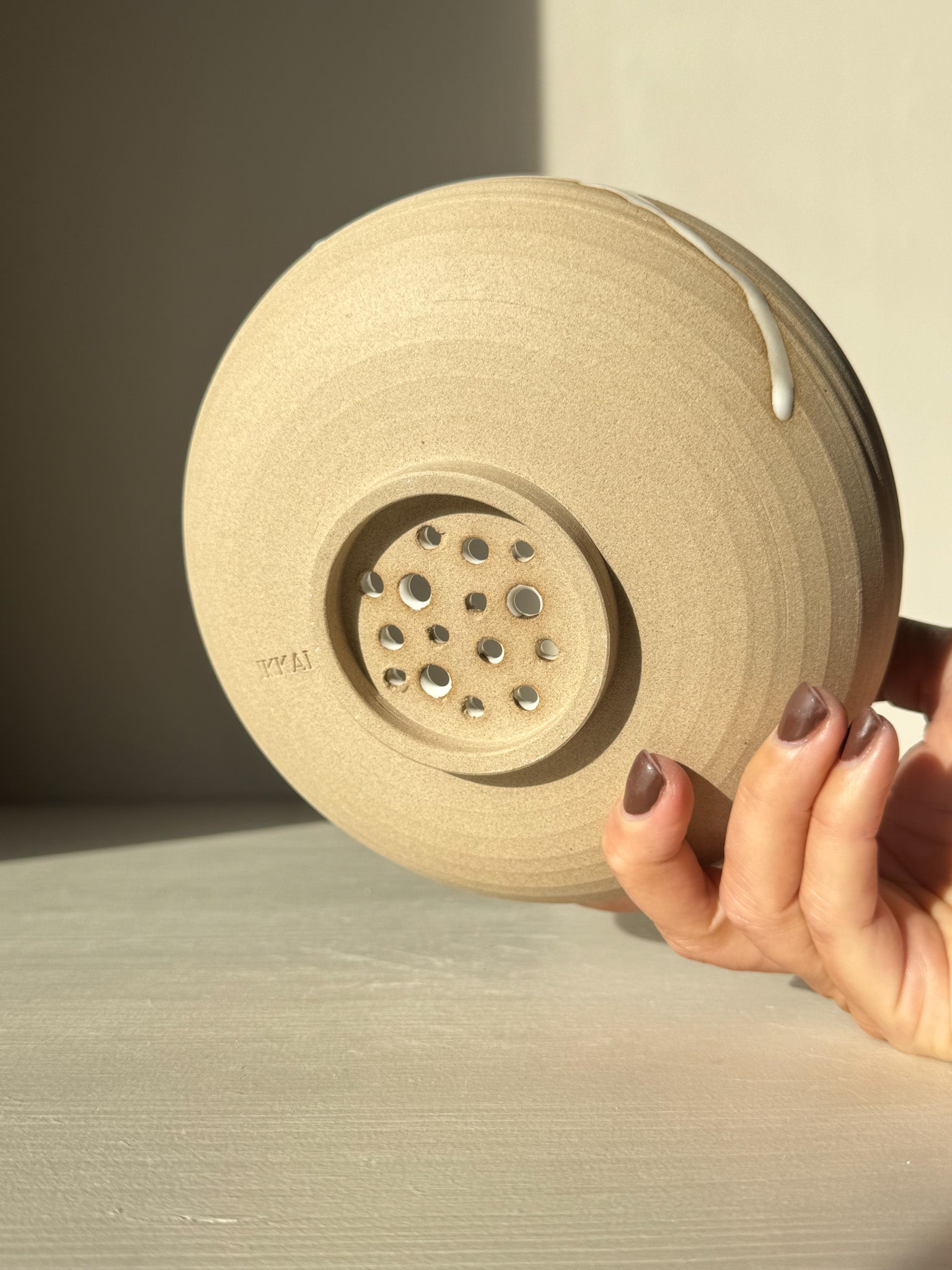 Underside of Rounded Berry Bowl - Yuki showing handmade holes for drainage in natural toffee clay.