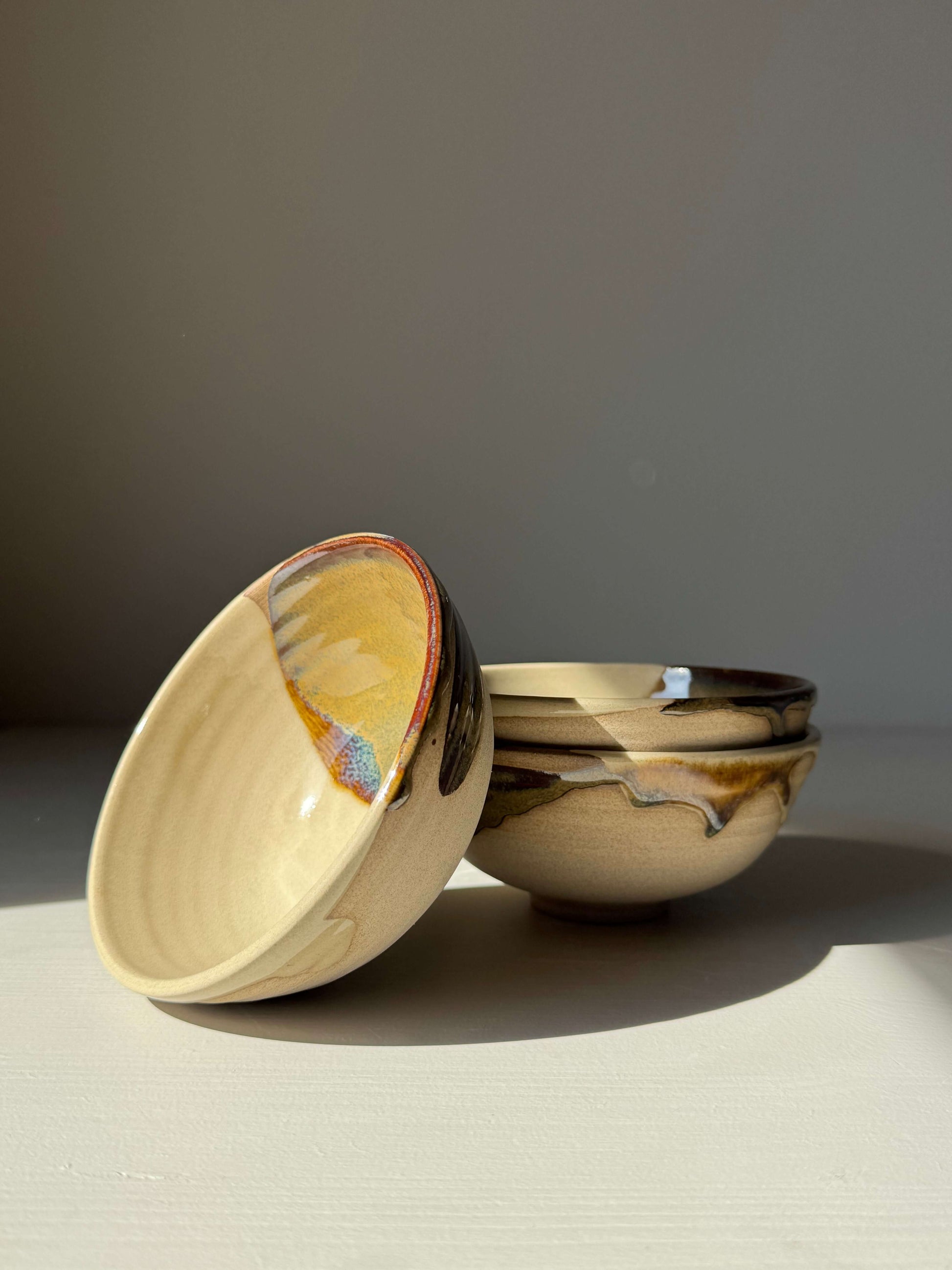 Handmade ceramic Small Bowl - Inyo with tenmoku glaze showcasing balance in form and texture on a light surface.