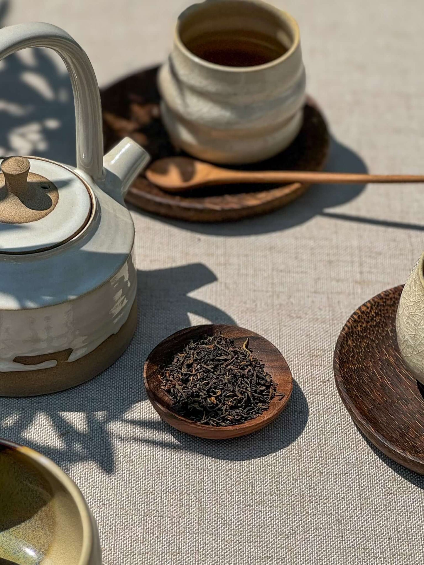 Small Walnut Wood Bowls with tea setup, featuring handmade ceramic teapot and cups, showcasing unique walnut grain and craftsmanship.