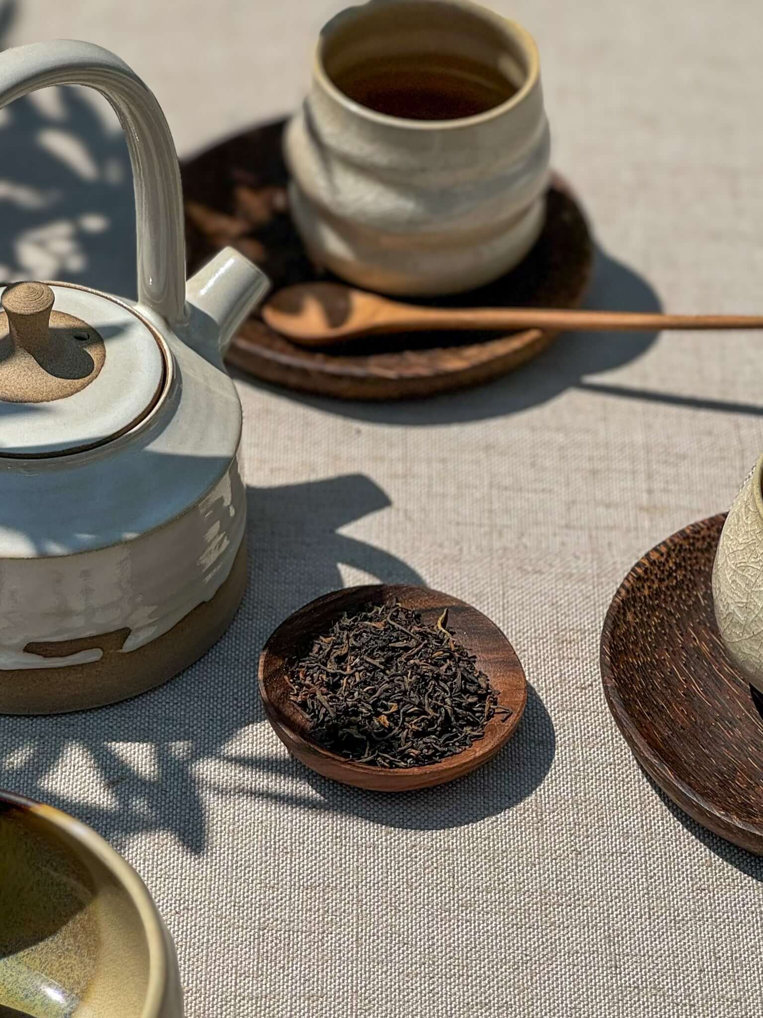 Small Walnut Wood Bowls with tea setup, featuring handmade ceramic teapot and cups, showcasing unique walnut grain and craftsmanship.