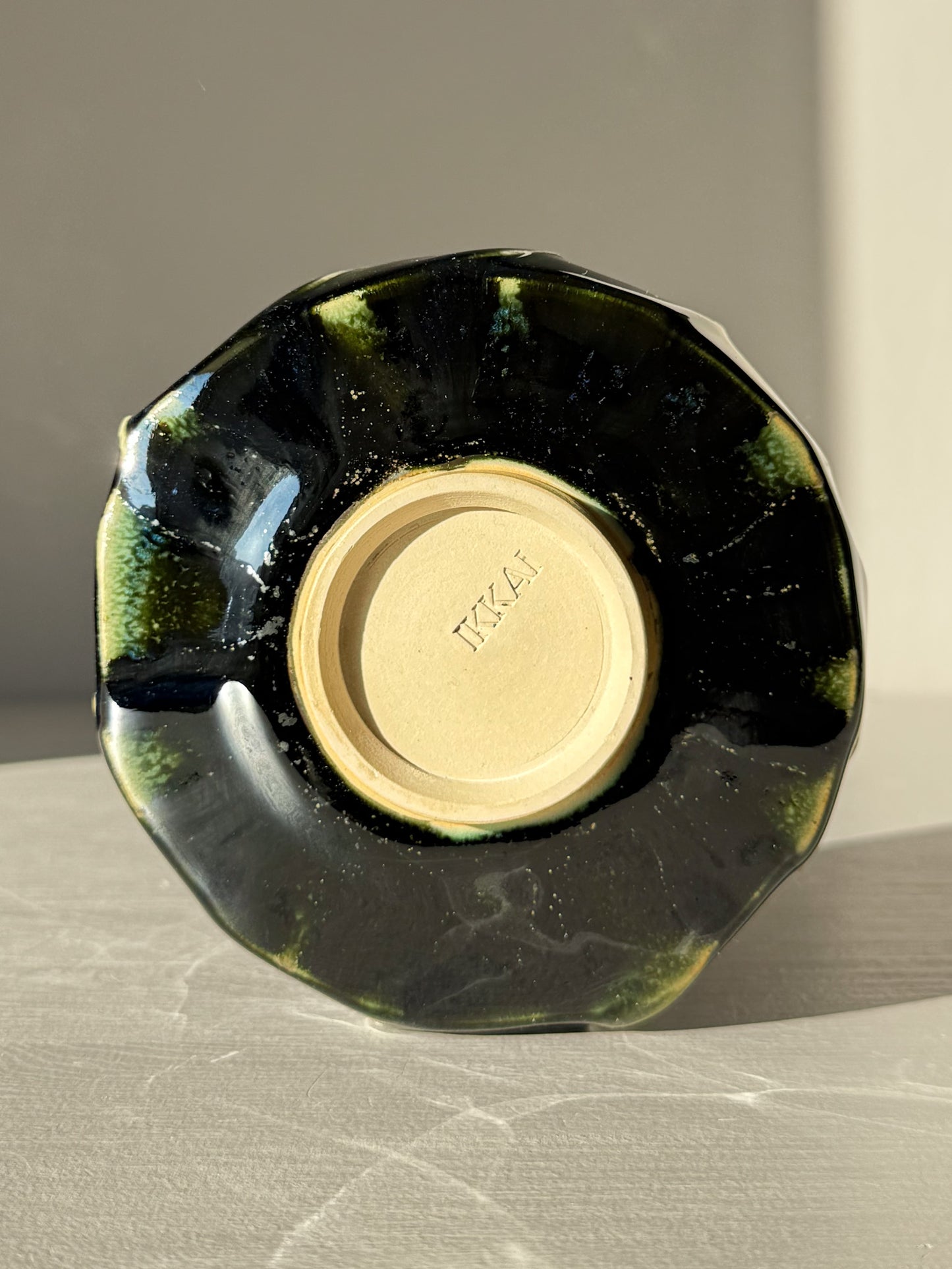 Underside view of Textured Matcha Bowl - Hinoki #09 showcasing its unique green glaze and textured finish