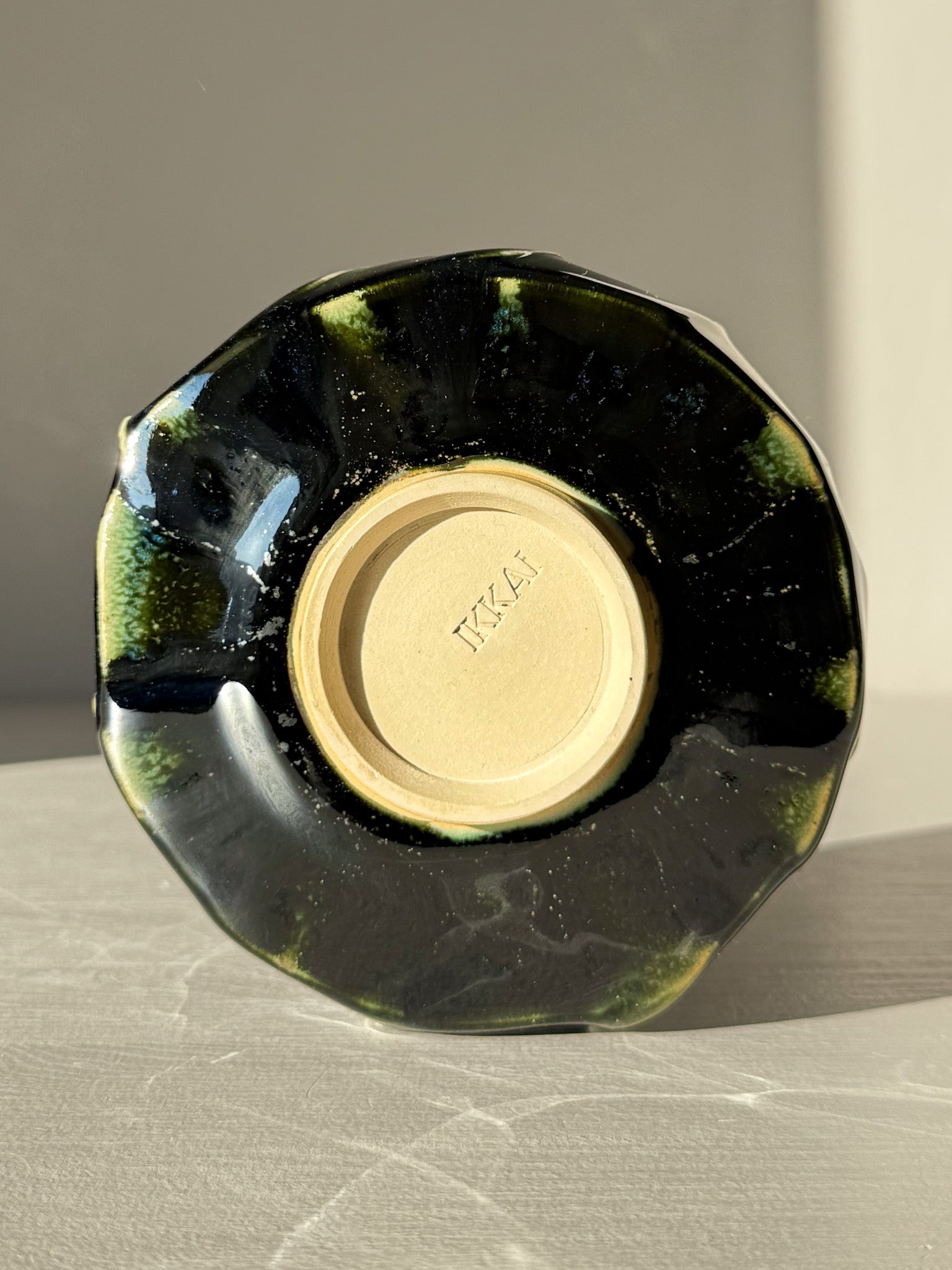 Underside view of Textured Matcha Bowl - Hinoki #09 showcasing its unique green glaze and textured finish