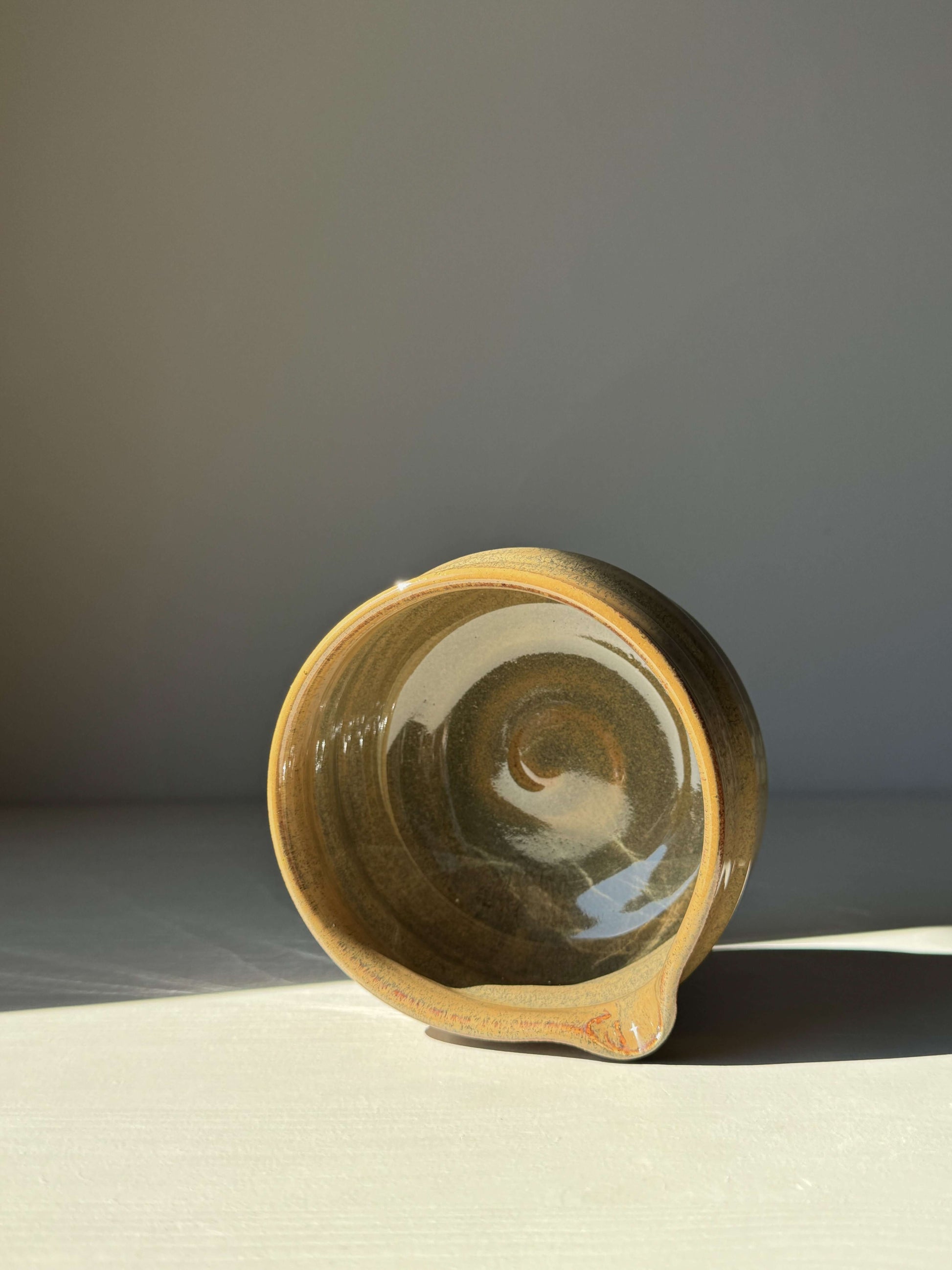 Hand-thrown Matcha bowl with a spout, featuring deep tenmoku glaze shifting from rich brown to soft green hues, ideal for daily use.