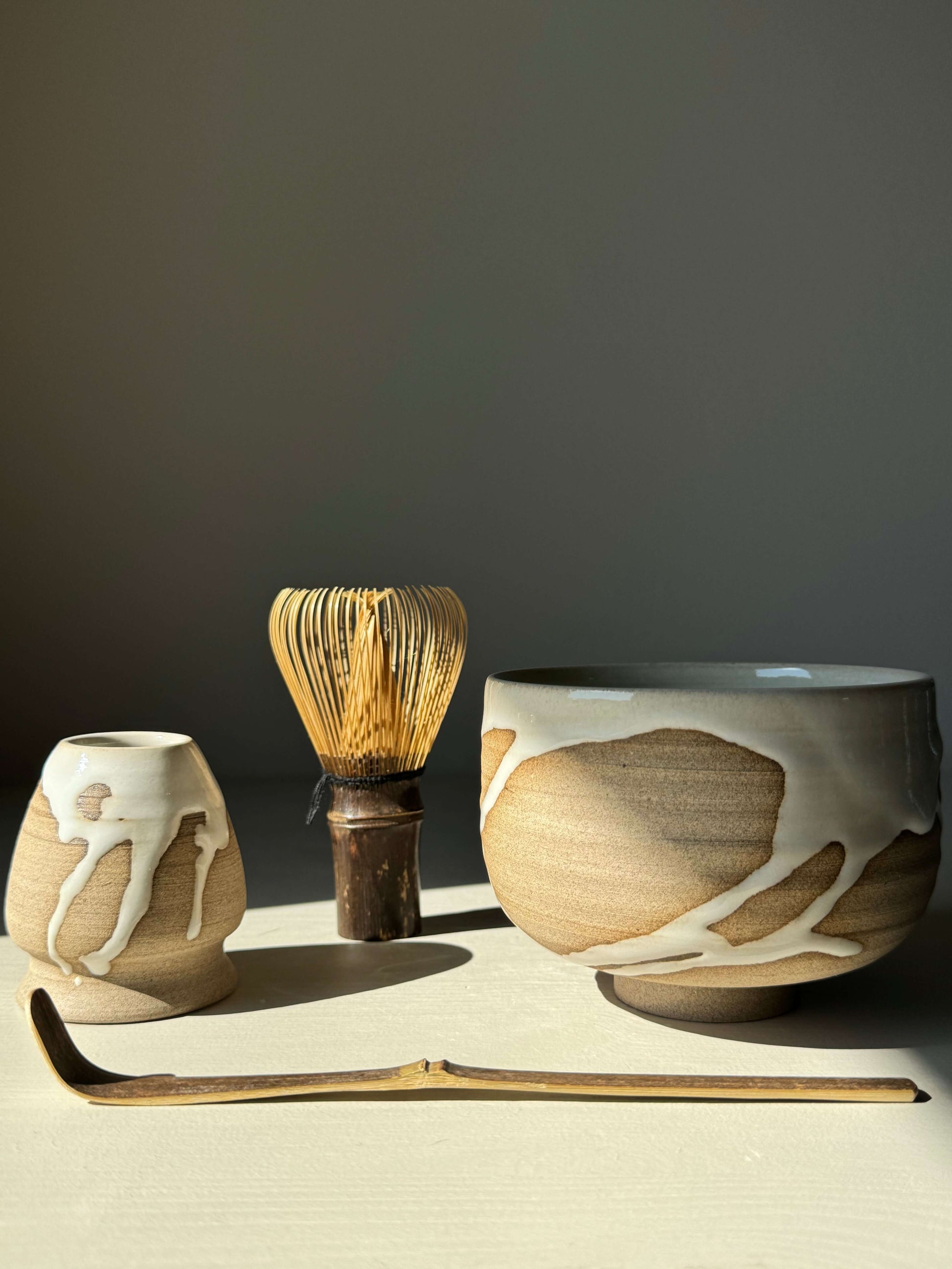 Handmade Matcha bowl from Yuki Series #11 with toffee clay and white glaze, featuring a whisk and holder, perfect for tea rituals.