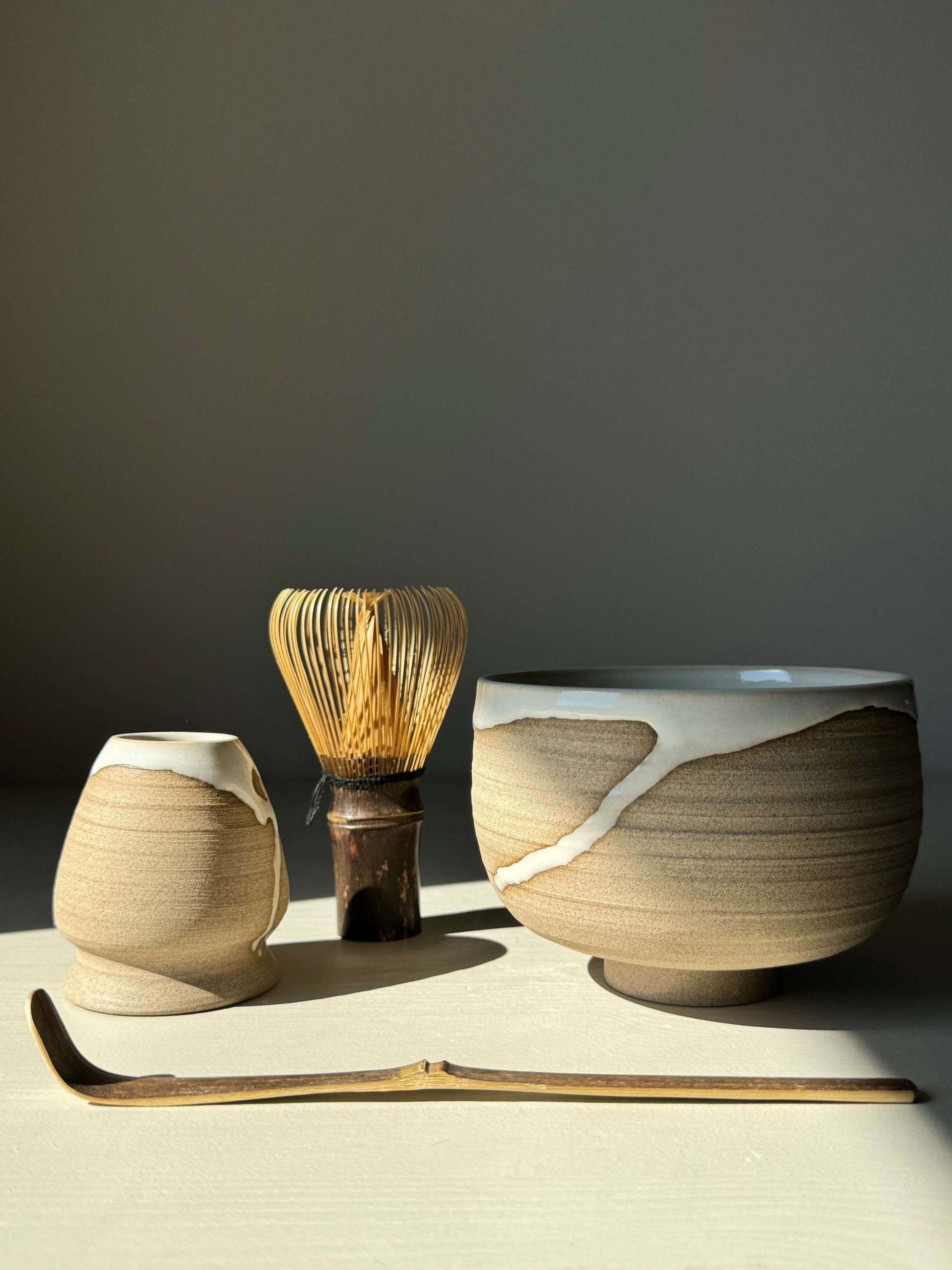 Handmade Yuki Series Matcha bowl with whisk and scoop, featuring toffee clay and glossy white glaze for a unique, calming tea ritual.