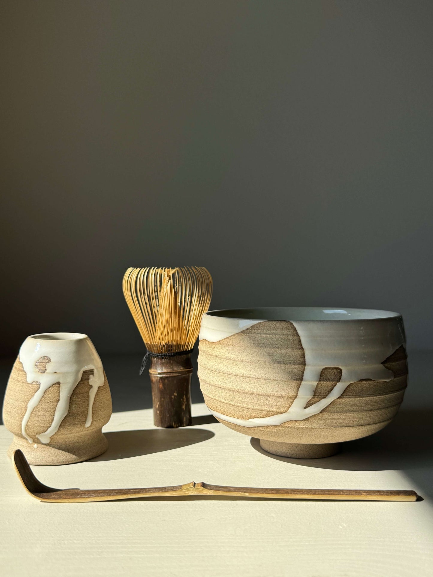 Matcha Bowl Yuki Series #07 with toffee clay and white glaze, handmade with natural glaze patterns, alongside whisk and scoop.