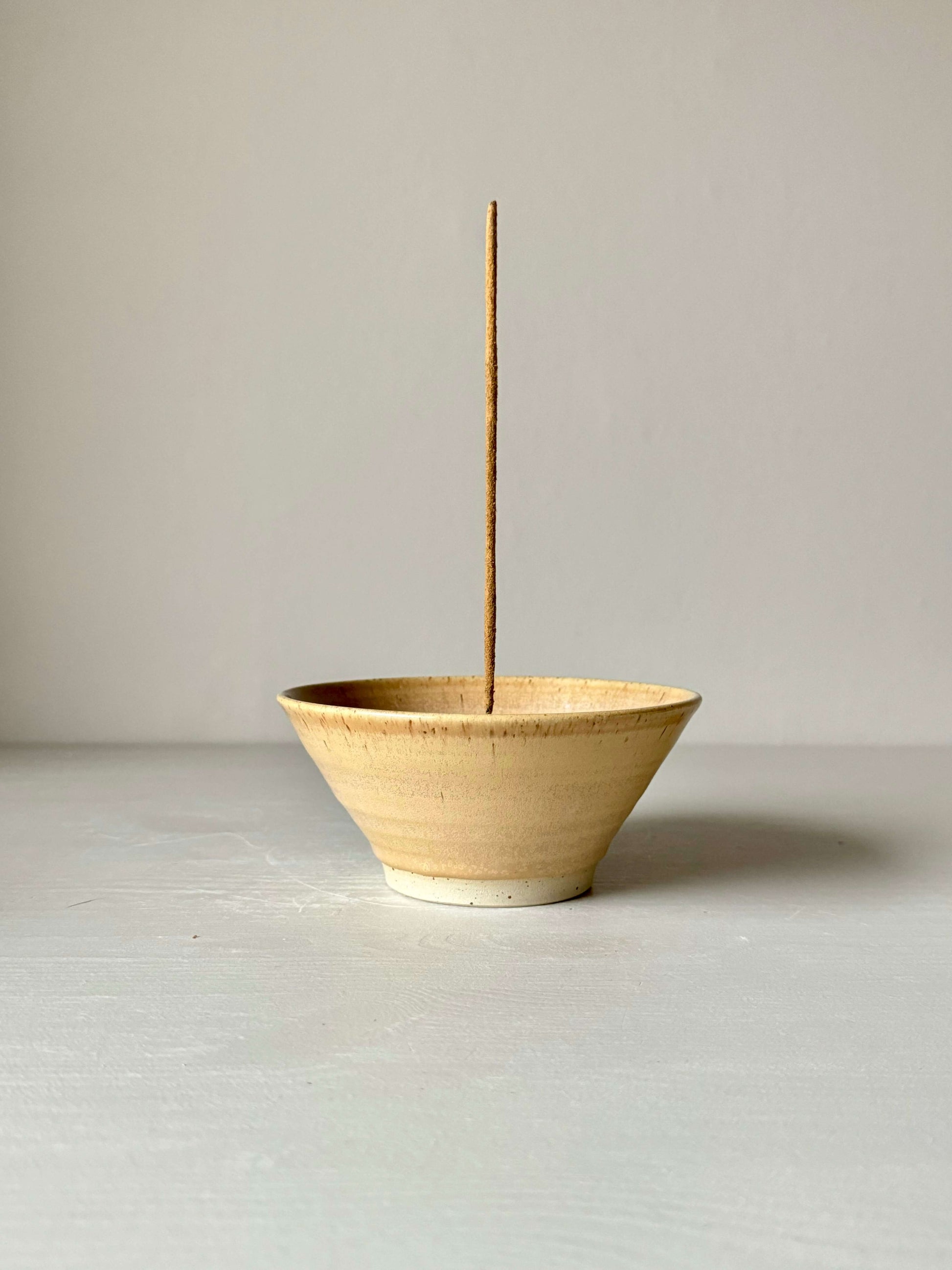 Handmade peach-glazed stoneware incense holder with stick, 6cm high and 13cm in diameter, showcasing elegant craftsmanship.