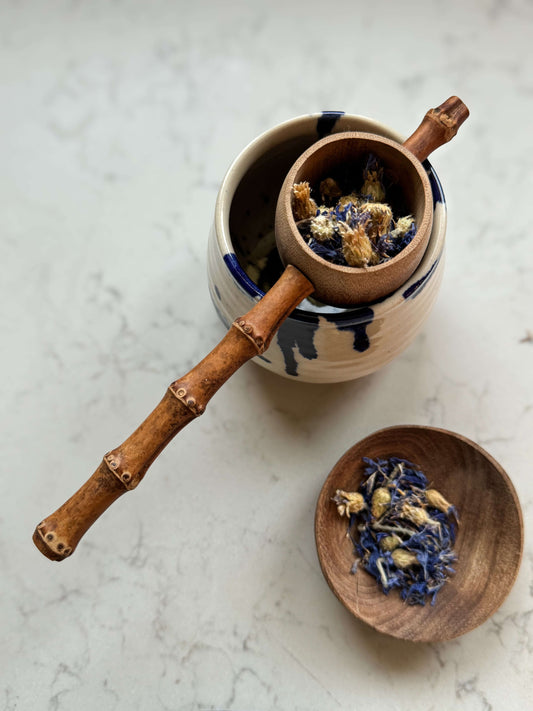 Handmade bamboo tea strainer with rustic design, resting on a ceramic mug, ideal for brewing loose leaf tea.