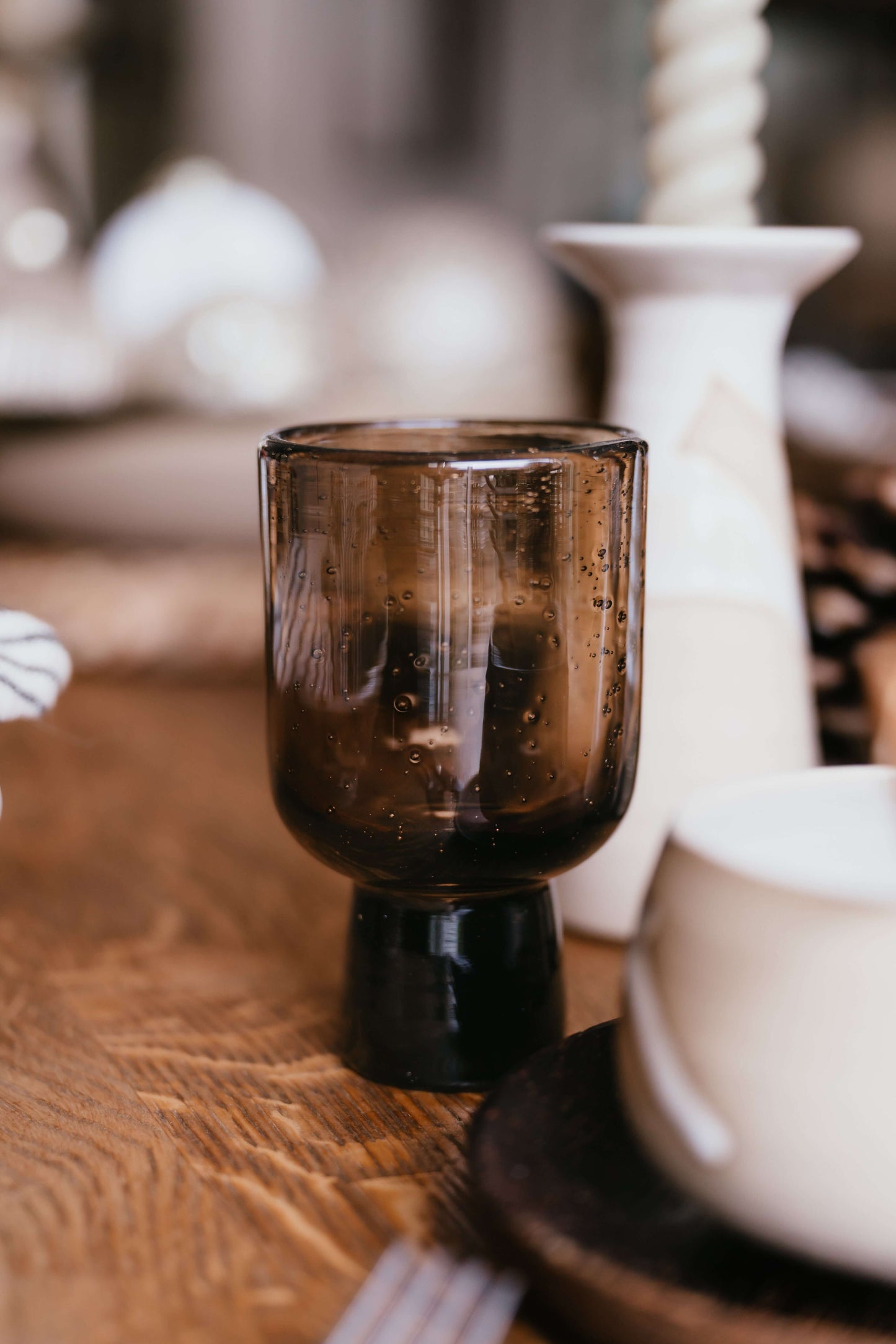 Brown Pedestal Glass – Natural Bubbled Glass, handmade ceramic table setting on wooden surface.