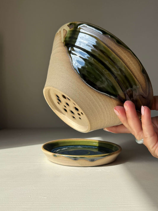 Handmade ceramic Berry Bowl - Mori Series with deep forest tones design, shown held above matching saucer.