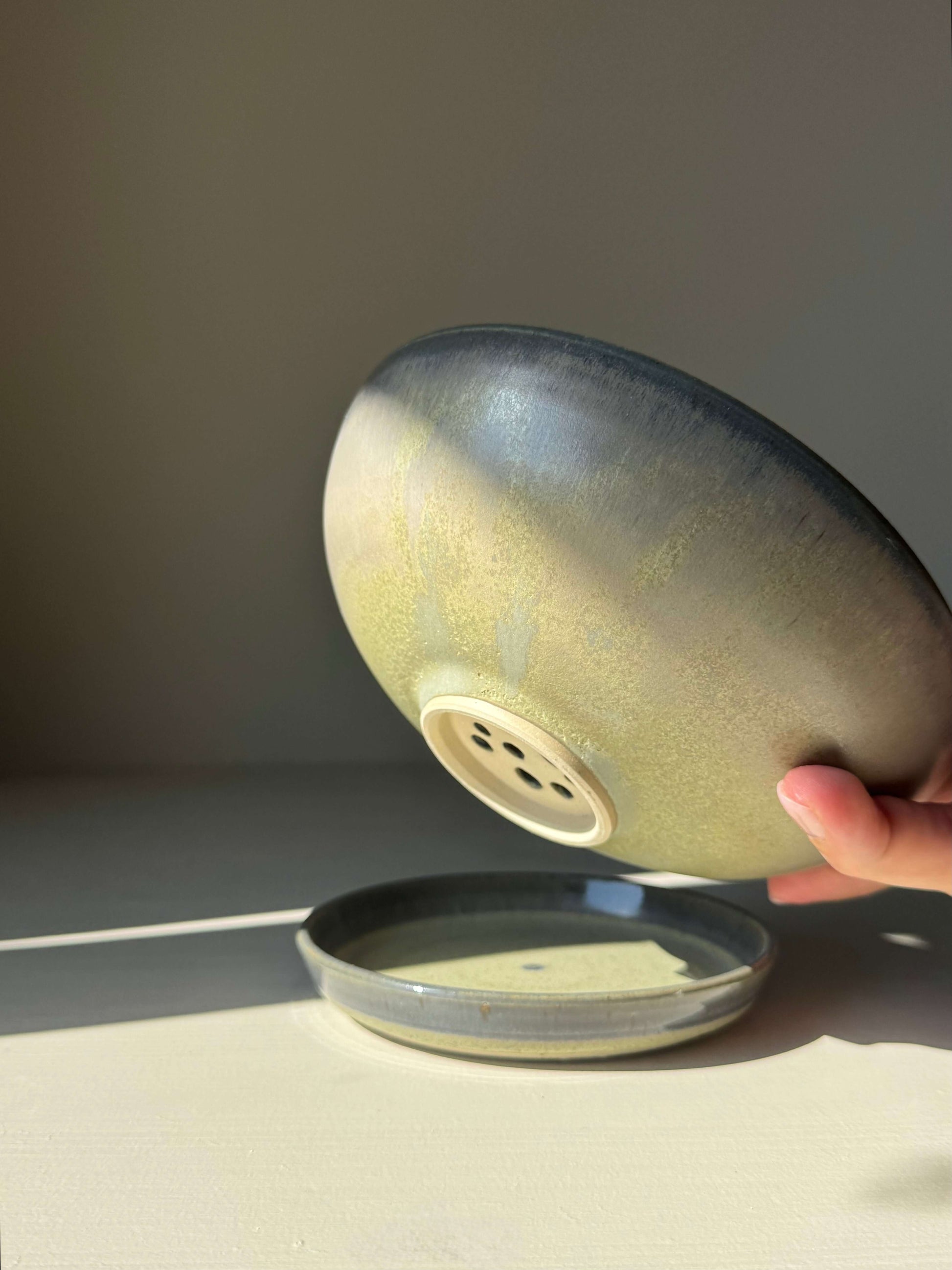 Handmade ceramic Berry Bowl - Satin Blue with drainage holes and matching drip plate, featuring a soft blue-green and smoky grey-blue satin glaze.