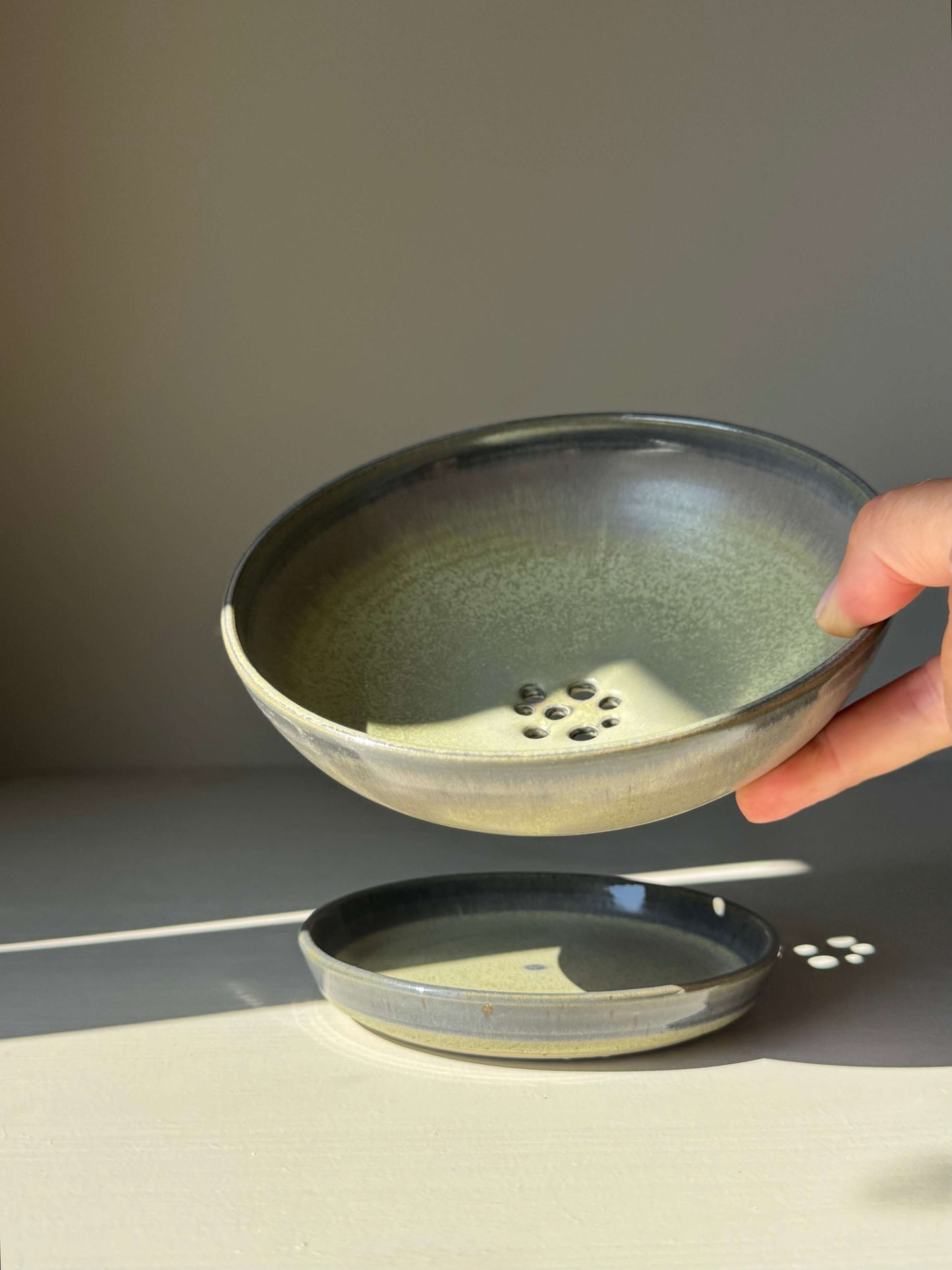 Handmade ceramic Berry Bowl - Satin Blue with drainage holes and matching drip plate, finished in a satin glaze with blue-green hues.