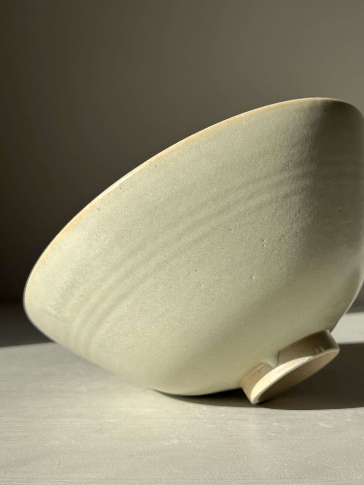 Handmade ceramic Bowl - Moonstone #02 with moonstone glaze, rounded form and raised foot, approx. 9cm x 19cm, displayed on side.