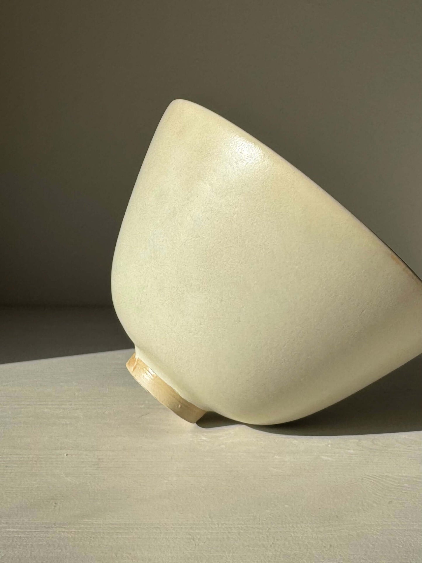 Handmade ceramic Bowl - Moonstone #01 with moonstone glaze, showcasing tall rounded form and raised foot in natural light.