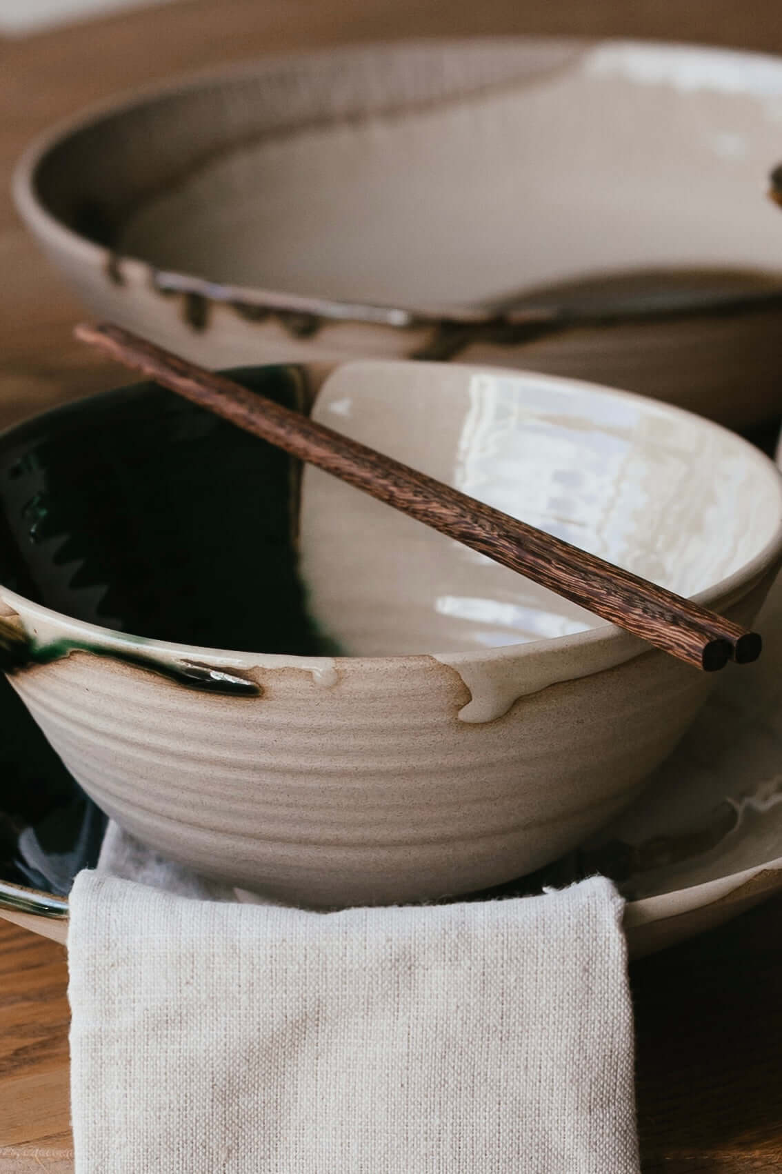 Wooden Chopsticks resting on a handmade ceramic bowl set, showcasing natural craftsmanship and elegance.