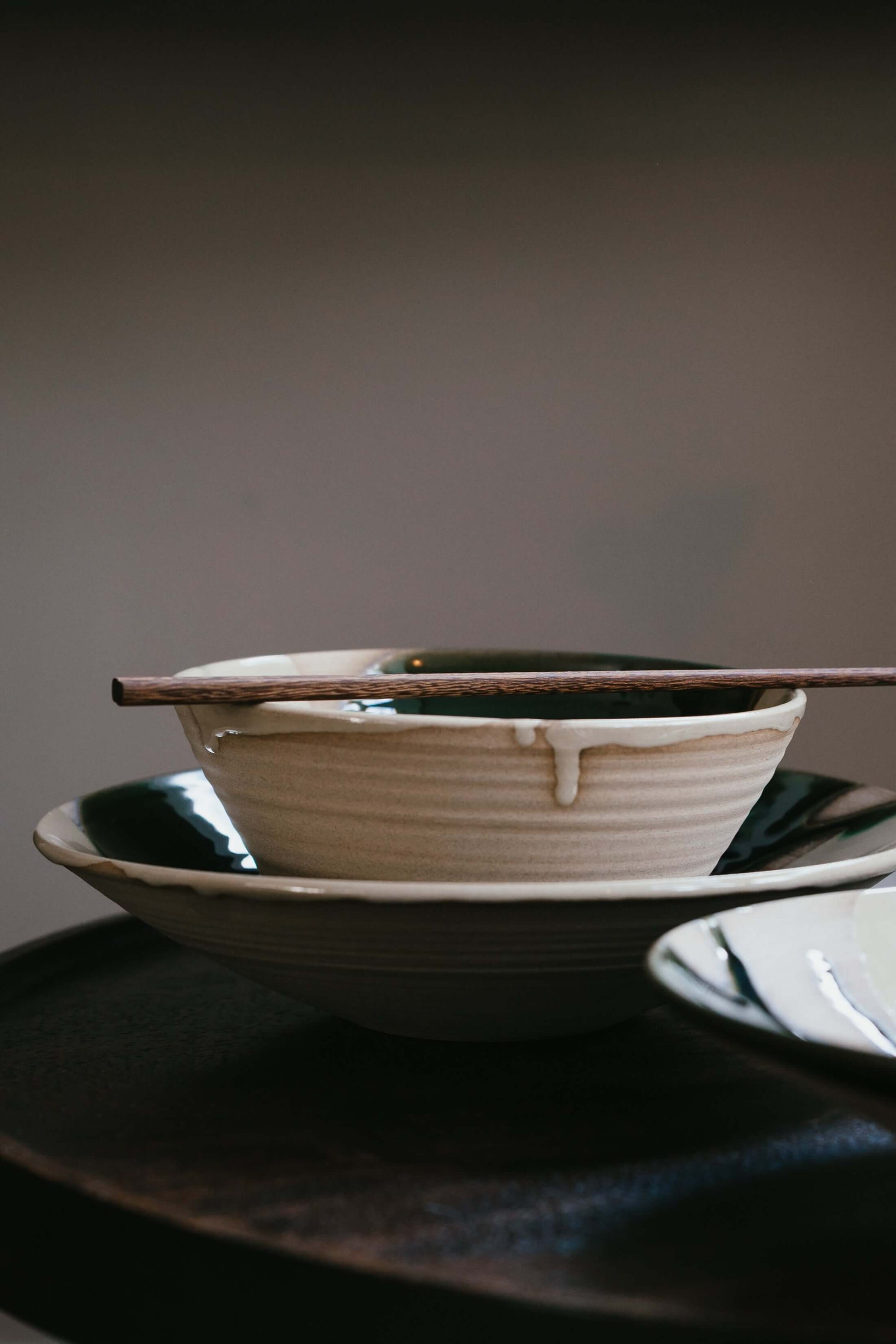 Handmade ceramic bowls with Wooden Chopsticks Set placed on top, showcasing natural craftsmanship and elegance.