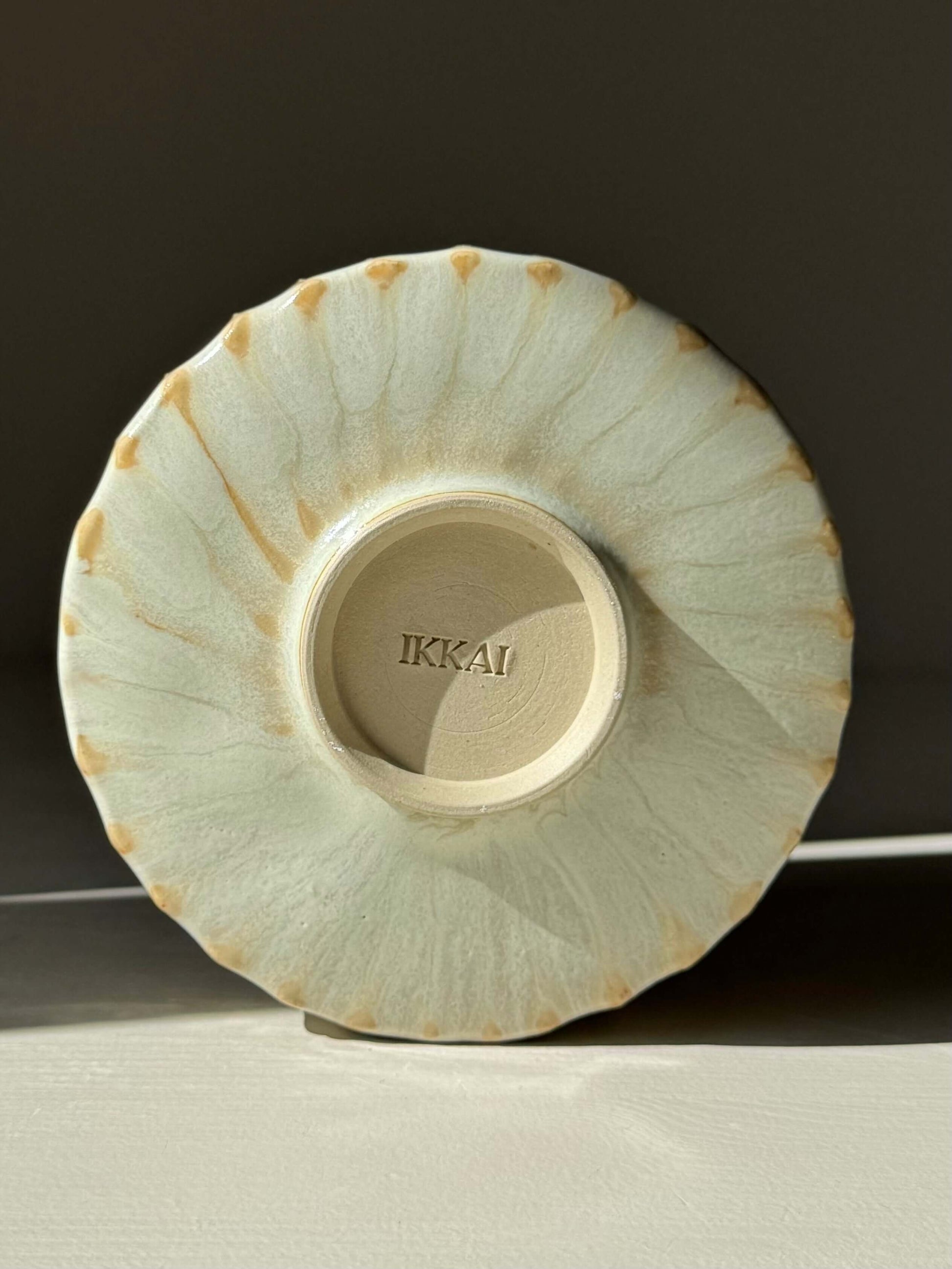 Base of Carved Matcha Bowl – Moonstone Glaze #01, handmade ceramic with intricate ridges and pale glaze finish, bottom view.