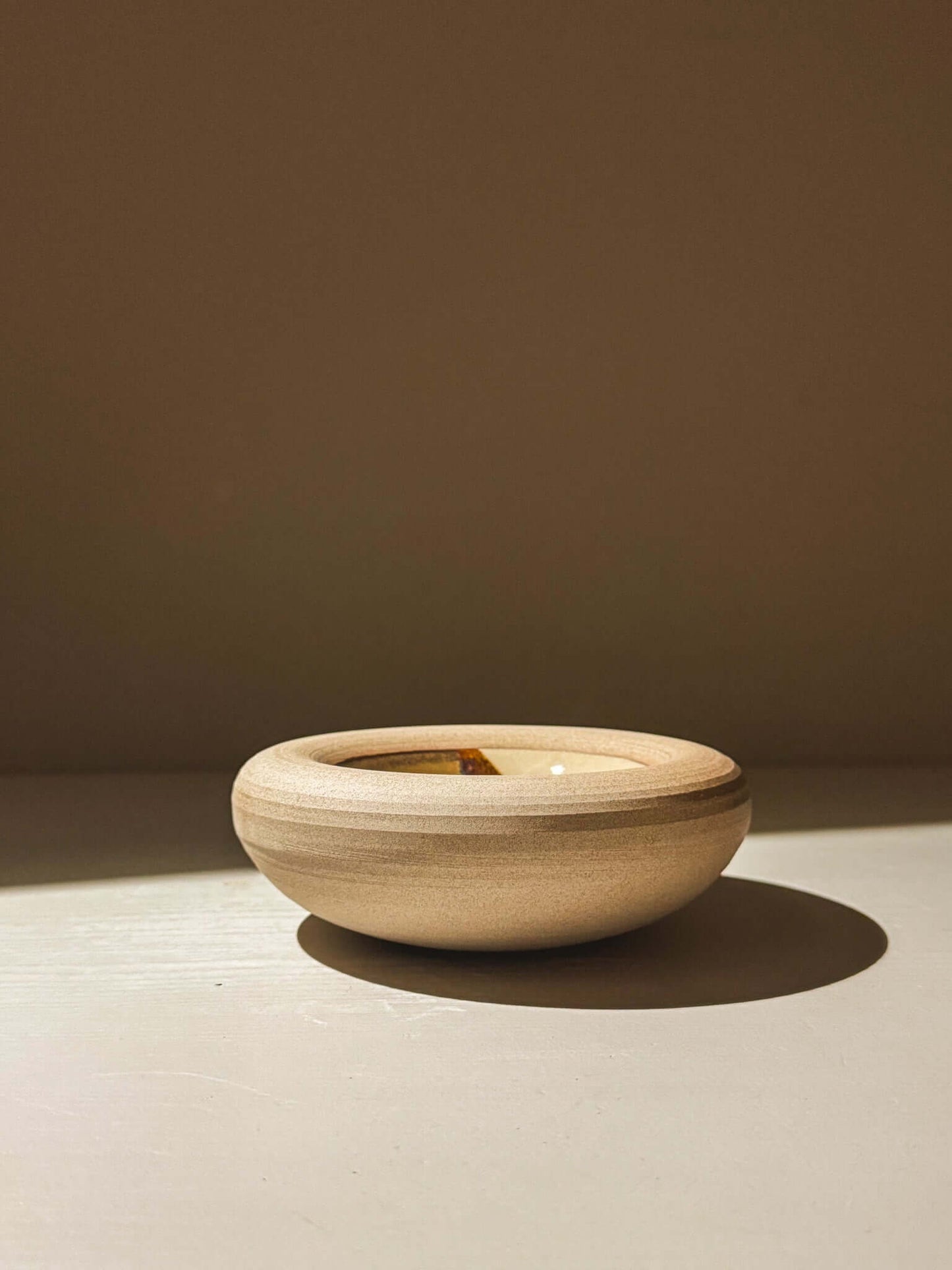 Handmade stoneware bowl from Inyo Series with double-walled design, featuring a toffee-toned clay exterior and melted glaze interior.