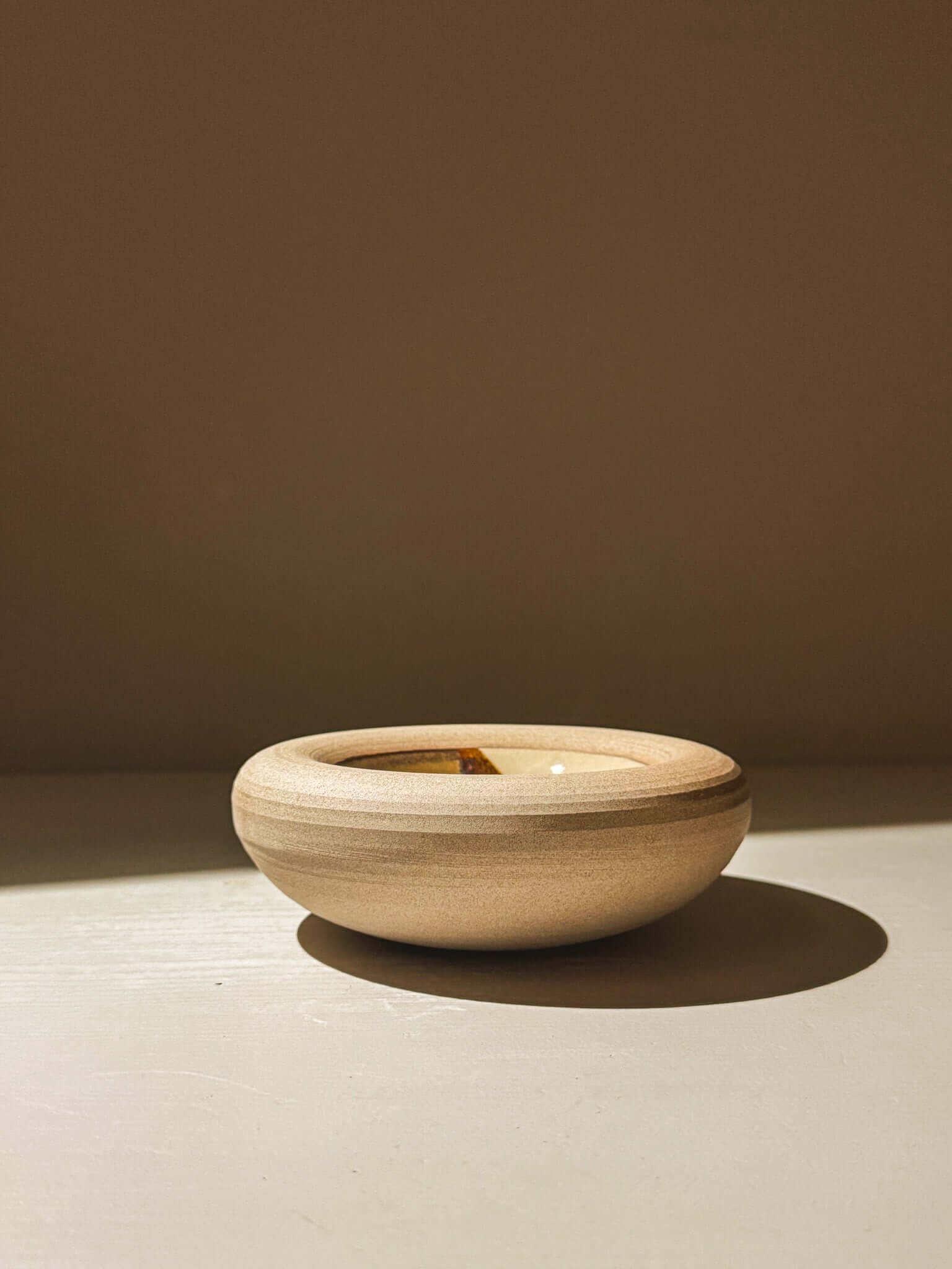 Handmade stoneware bowl from Inyo Series with double-walled design, featuring a toffee-toned clay exterior and melted glaze interior.
