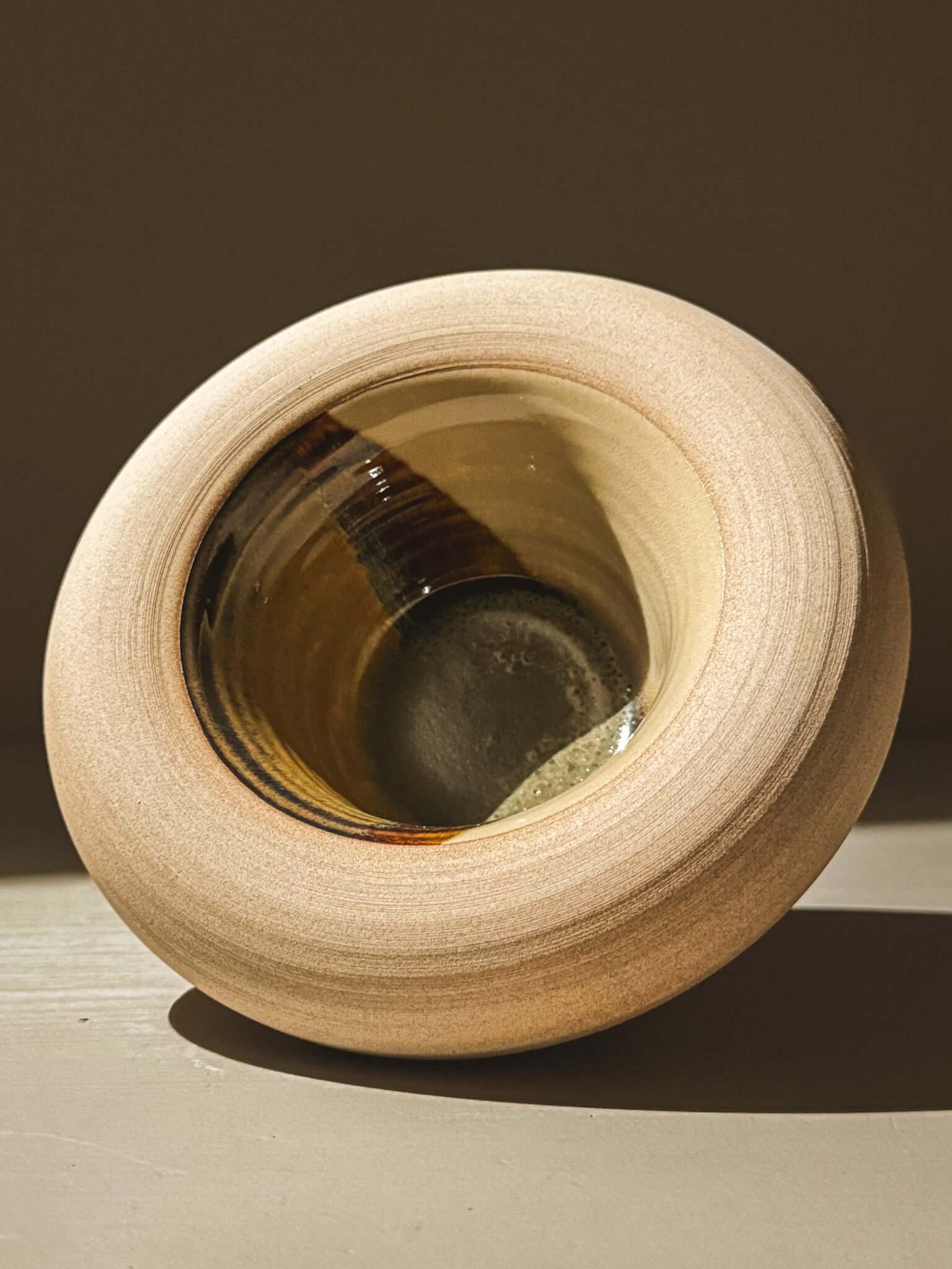 Handmade double-walled stoneware bowl with clear and tenmoku glazes from the Inyo Series, featuring toffee-toned clay exterior.