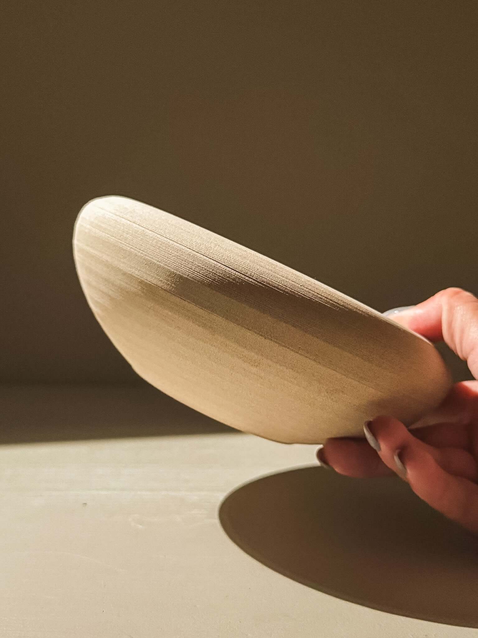 Side view of handmade stoneware double-walled bowl, showing raw toffee-toned clay with gentle throwing lines.