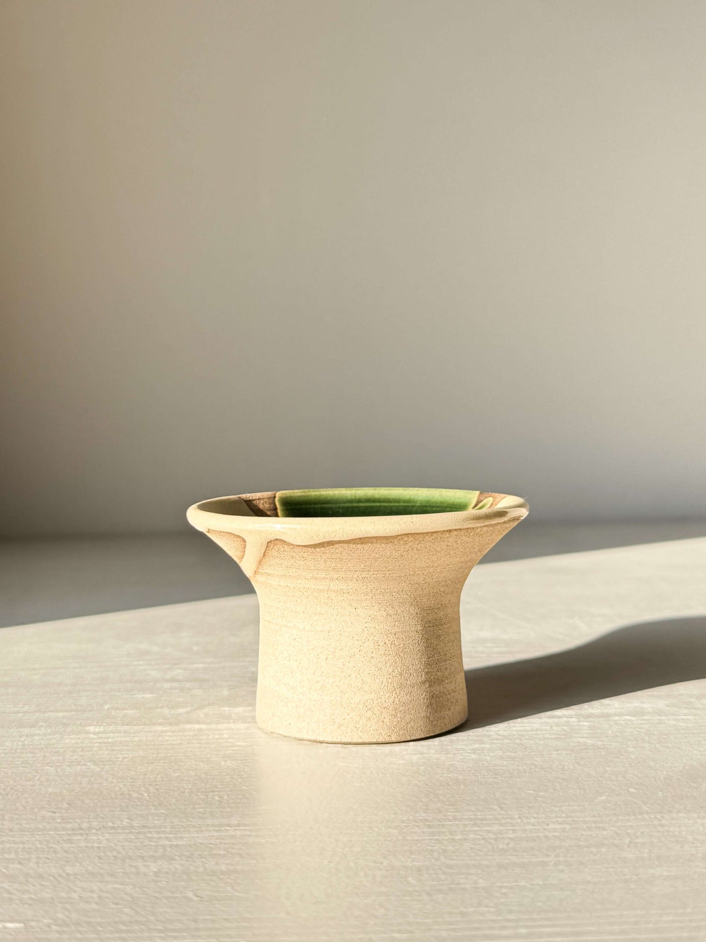 Egg Cup - Mori, a handmade ceramic with soft green Mori glaze on warm stoneware, wide rim design for holding eggs, photographed on a light surface.