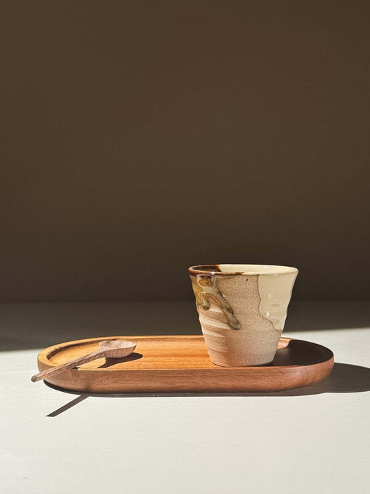 Espresso Cup - Inyo #01 on a wooden tray with a spoon, showcasing unique glaze patterns and textures.