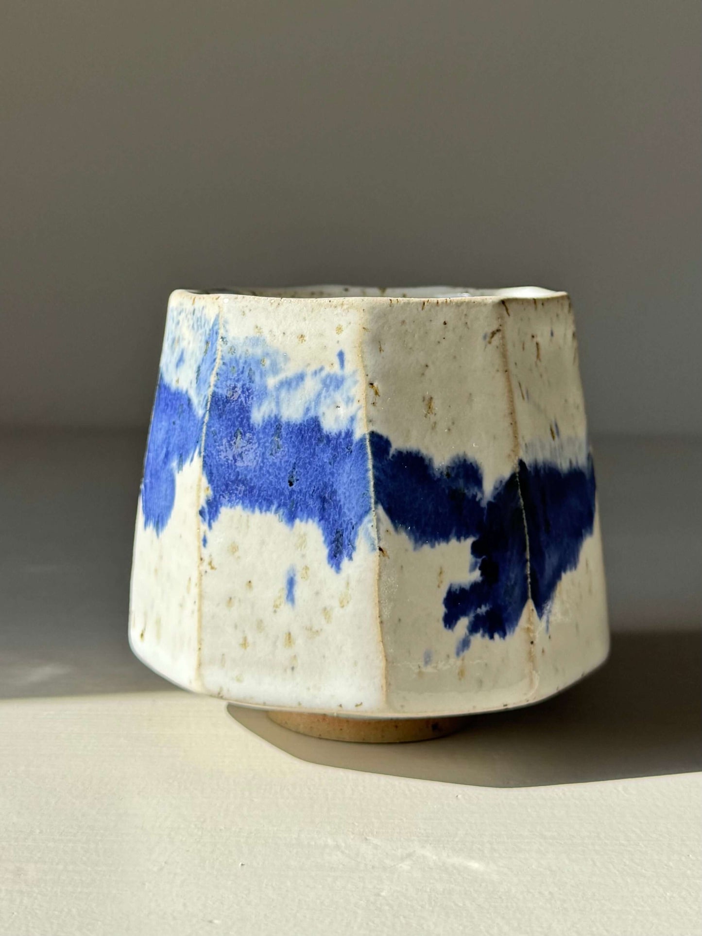 Handmade ceramic Faceted Cup – Cobalt Blue & Glossy White #02 with unique blue splashes and faceted angles by artisan
