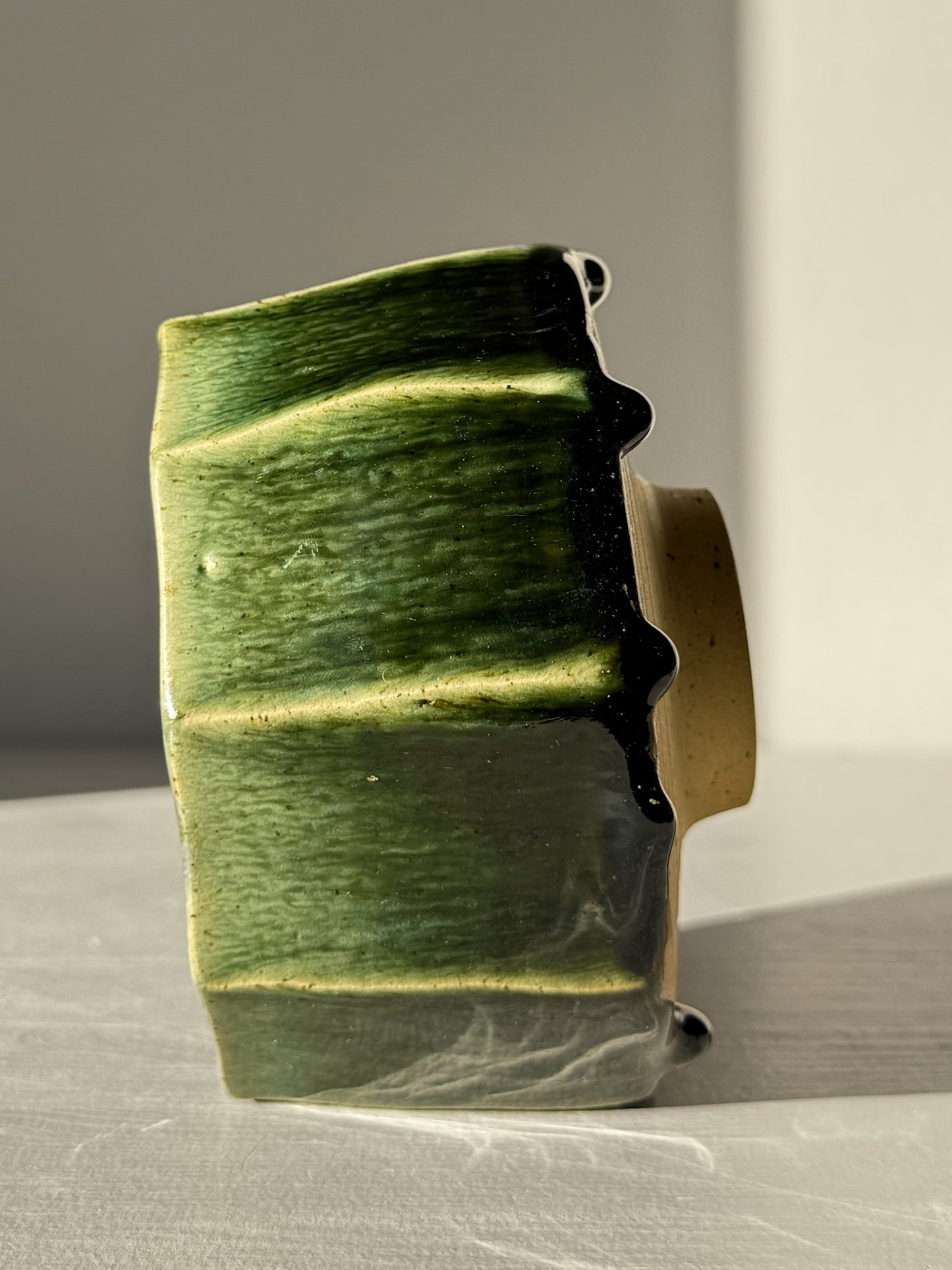 Faceted Matcha Bowl - Hinoki #02 with deep green glaze and hand-carved facets, showcasing its unique artistic appearance on display.