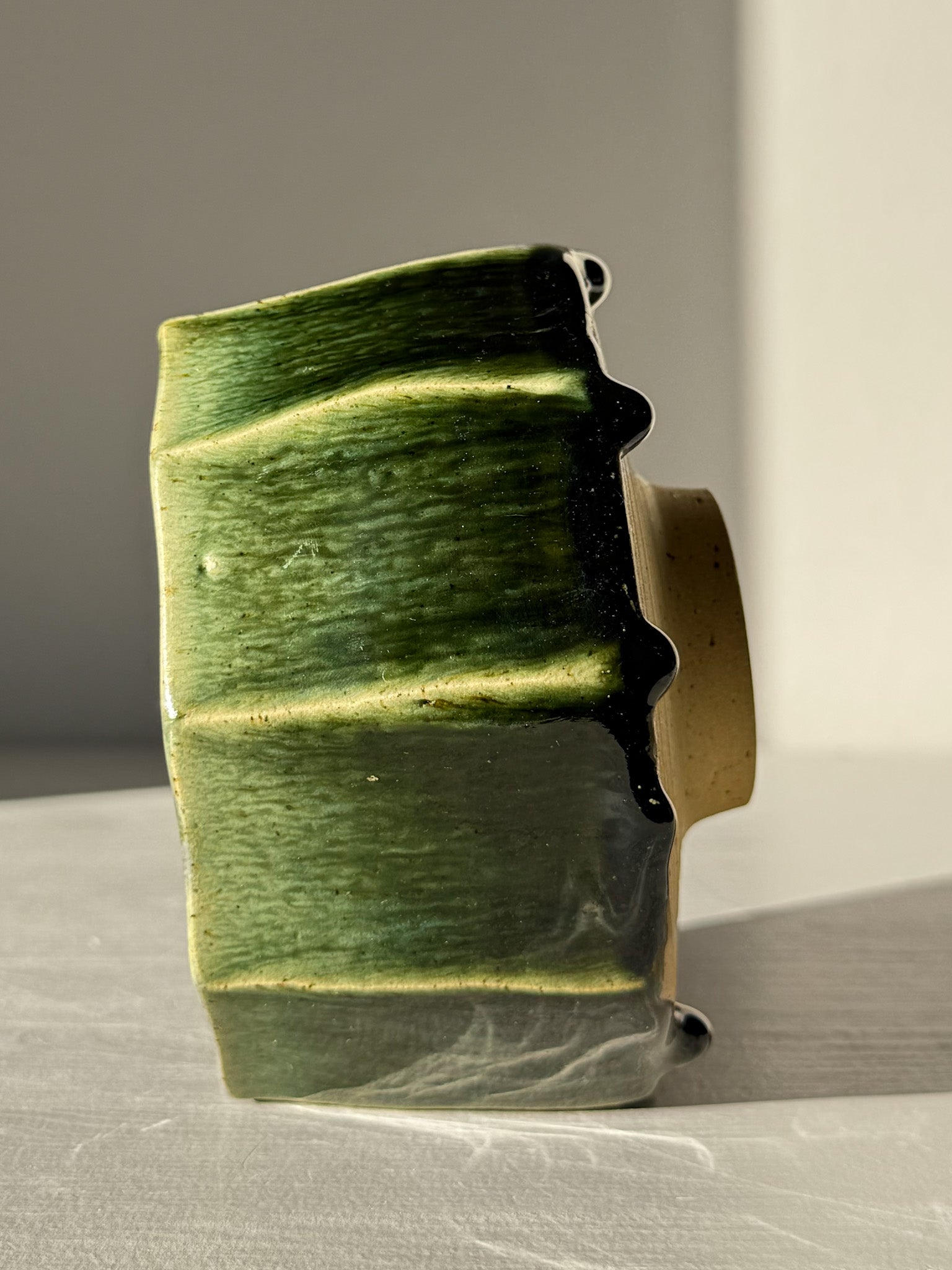 Faceted Matcha Bowl - Hinoki #02 with deep green glaze and hand-carved facets, showcasing its unique artistic appearance on display.