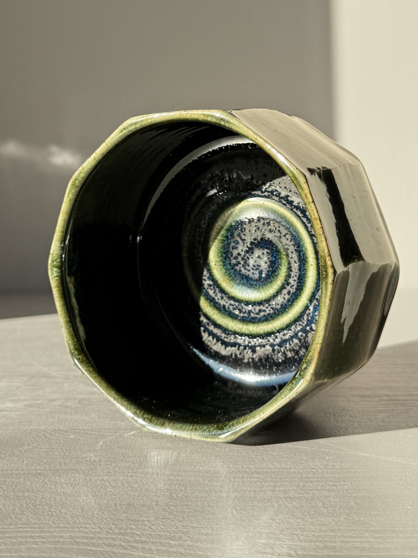 Faceted Matcha Bowl - Hinoki #01 with deep green glaze and hand-carved facets, highlighting unique swirling patterns inside.