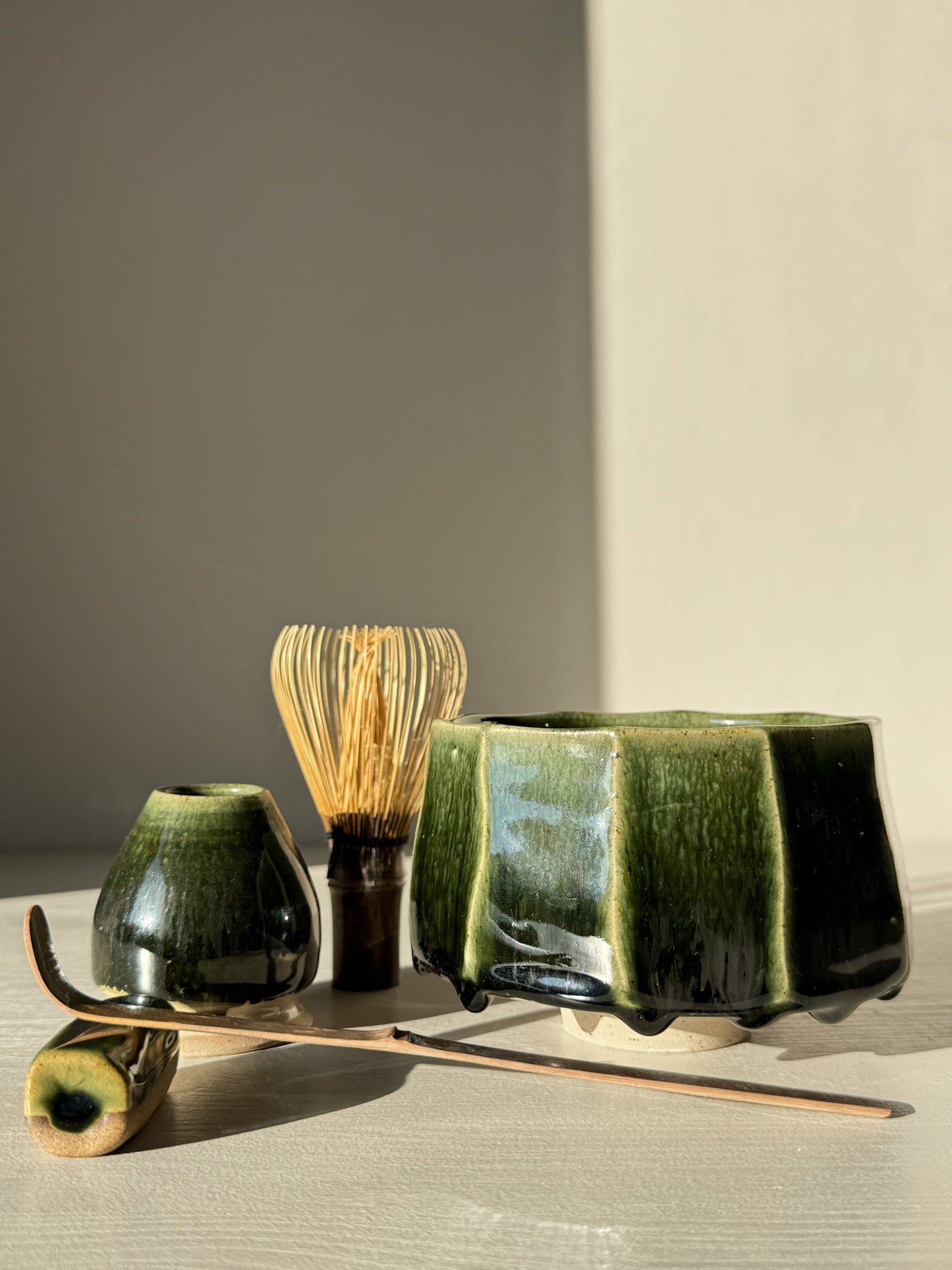 Faceted Matcha Bowl - Hinoki #02 with deep green glaze and hand-carved facets, part of the Hinoki Series, displayed with tea accessories.