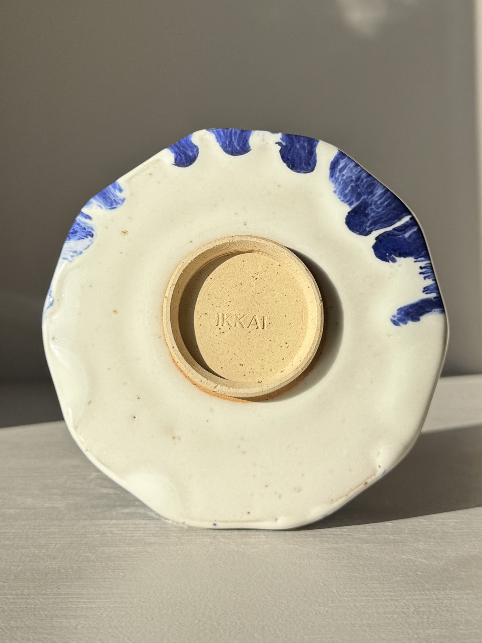 Base view of Faceted Matcha Bowl with Spout – White & Blue #02 showcasing hand-splashed cobalt blue accents and unique design.