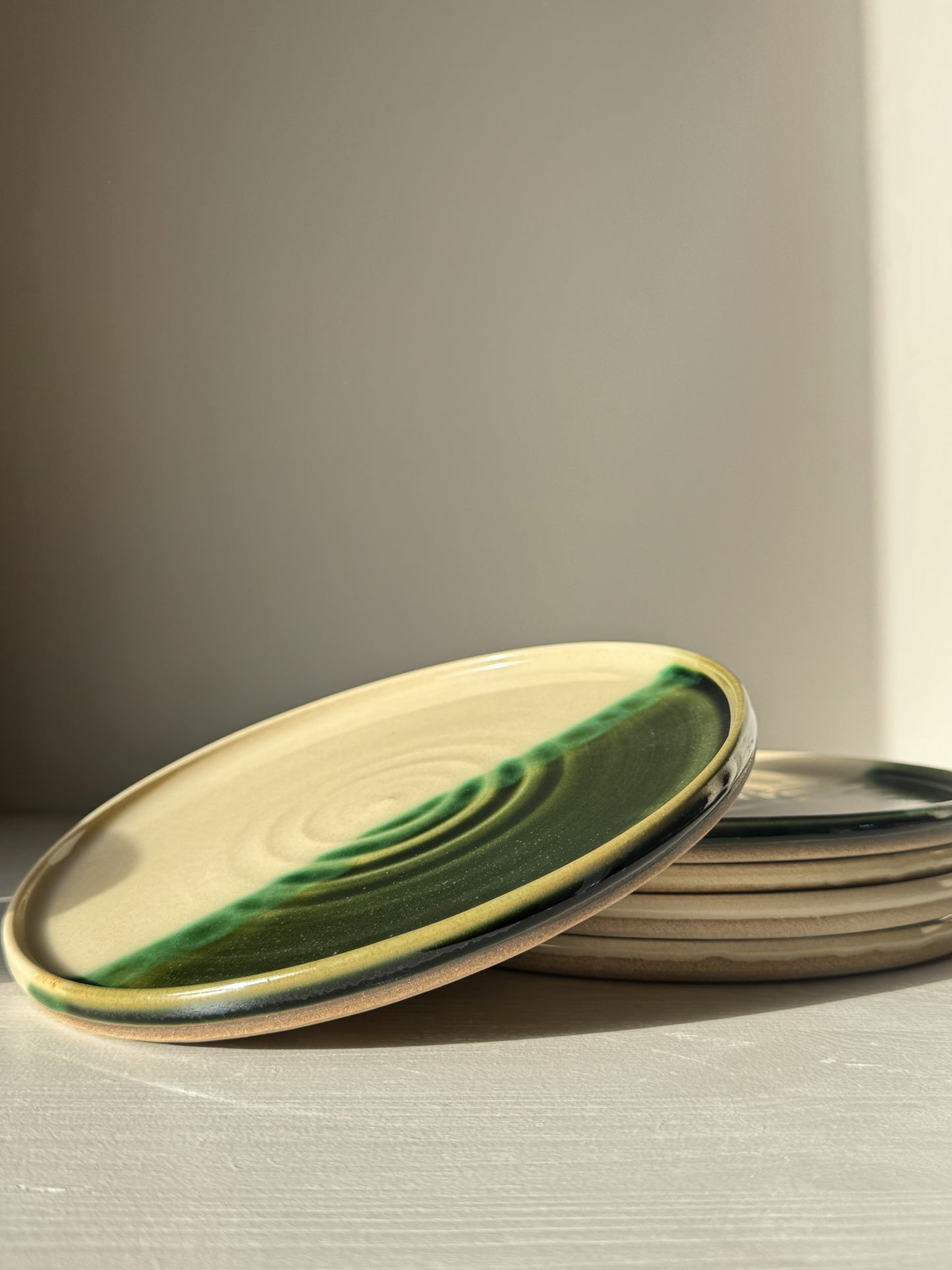 Flat Round Breakfast Plate – Mori with green and blue glaze on toffee clay, showing spiral design and glossy finish.
