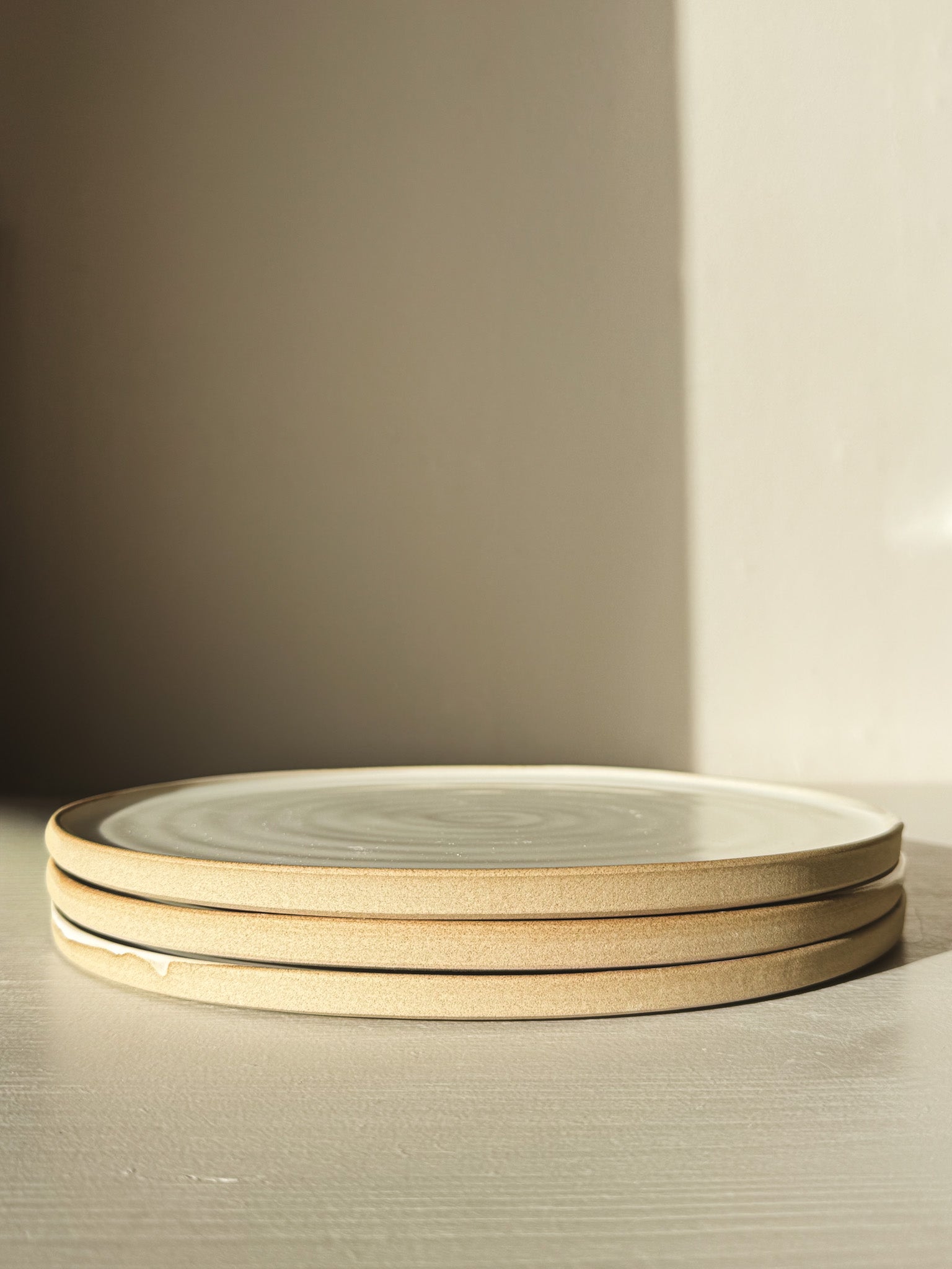 Flat Round Plate – Yuki Series stacked, featuring a soft white glaze over speckled stoneware, ideal for both everyday and special use.