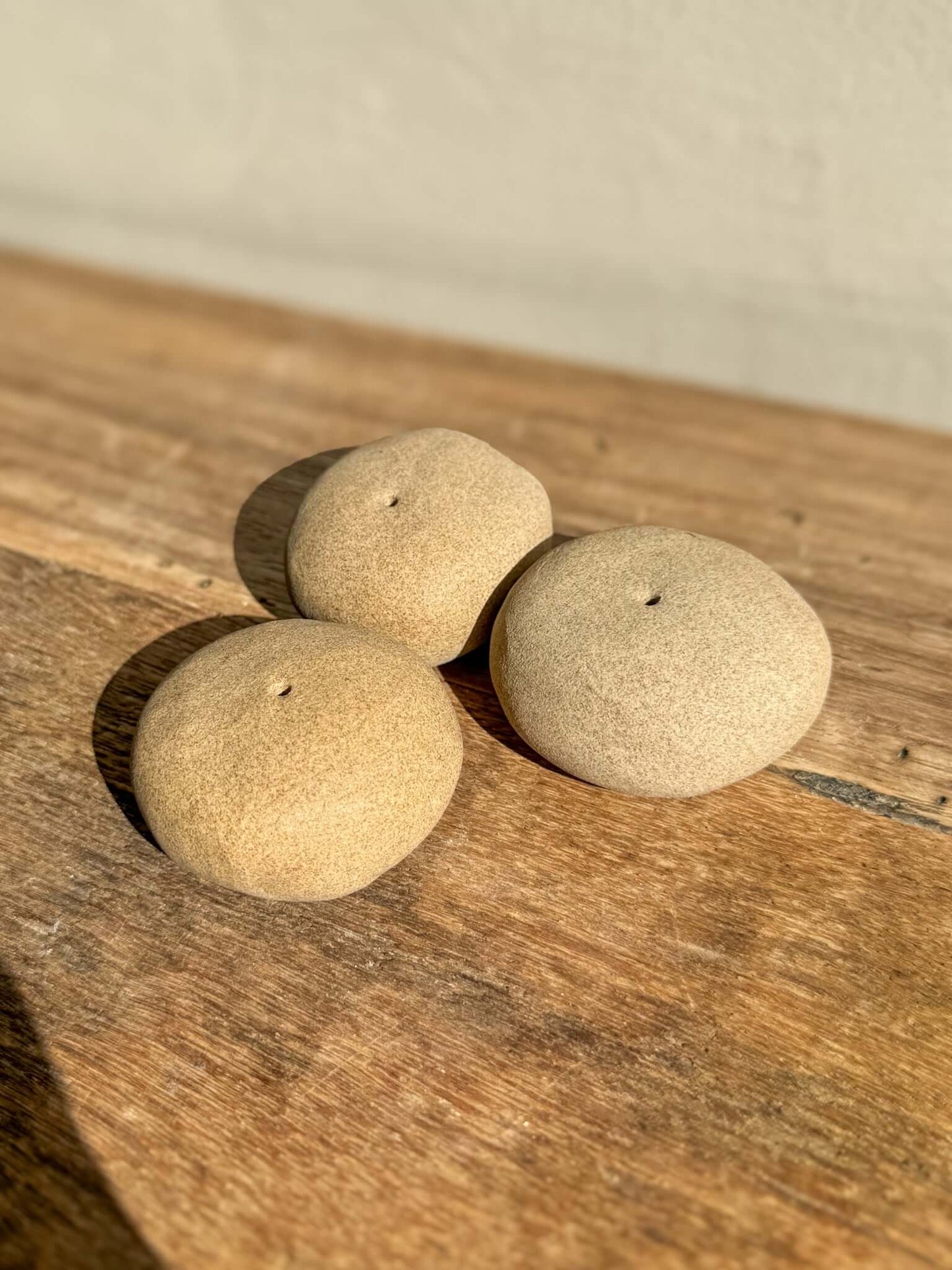 Handmade ceramic Incense Holder Pebbles on a wooden surface, shaped like river stones, ideal for holding a single incense stick.