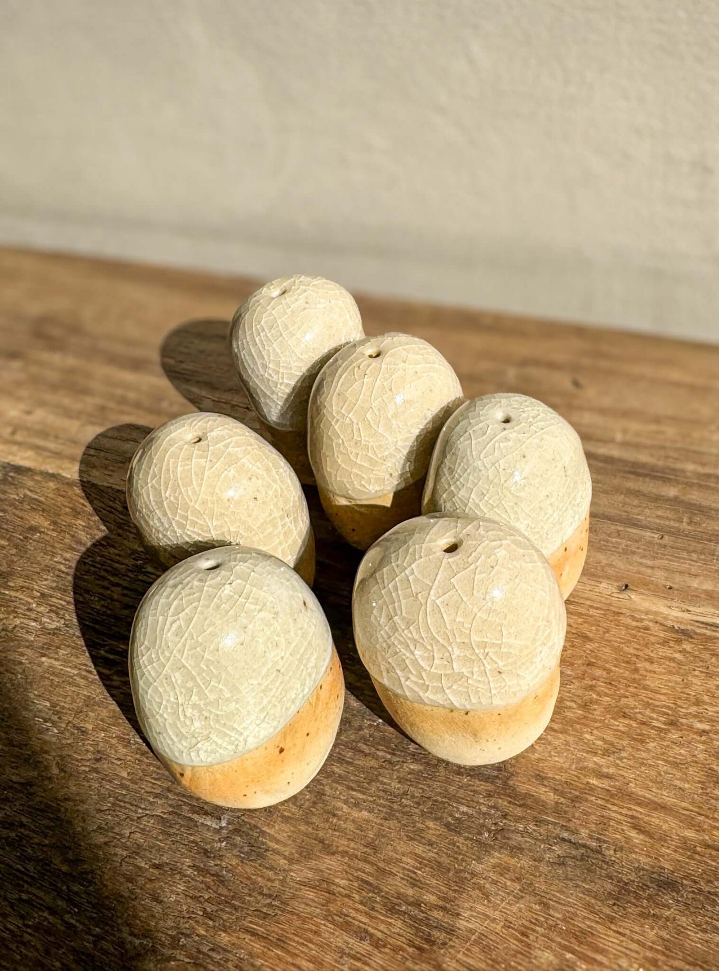 Handmade ceramic Incense Holder Pebbles resting on a wooden surface, showcasing their unique, natural stone-like design and texture.