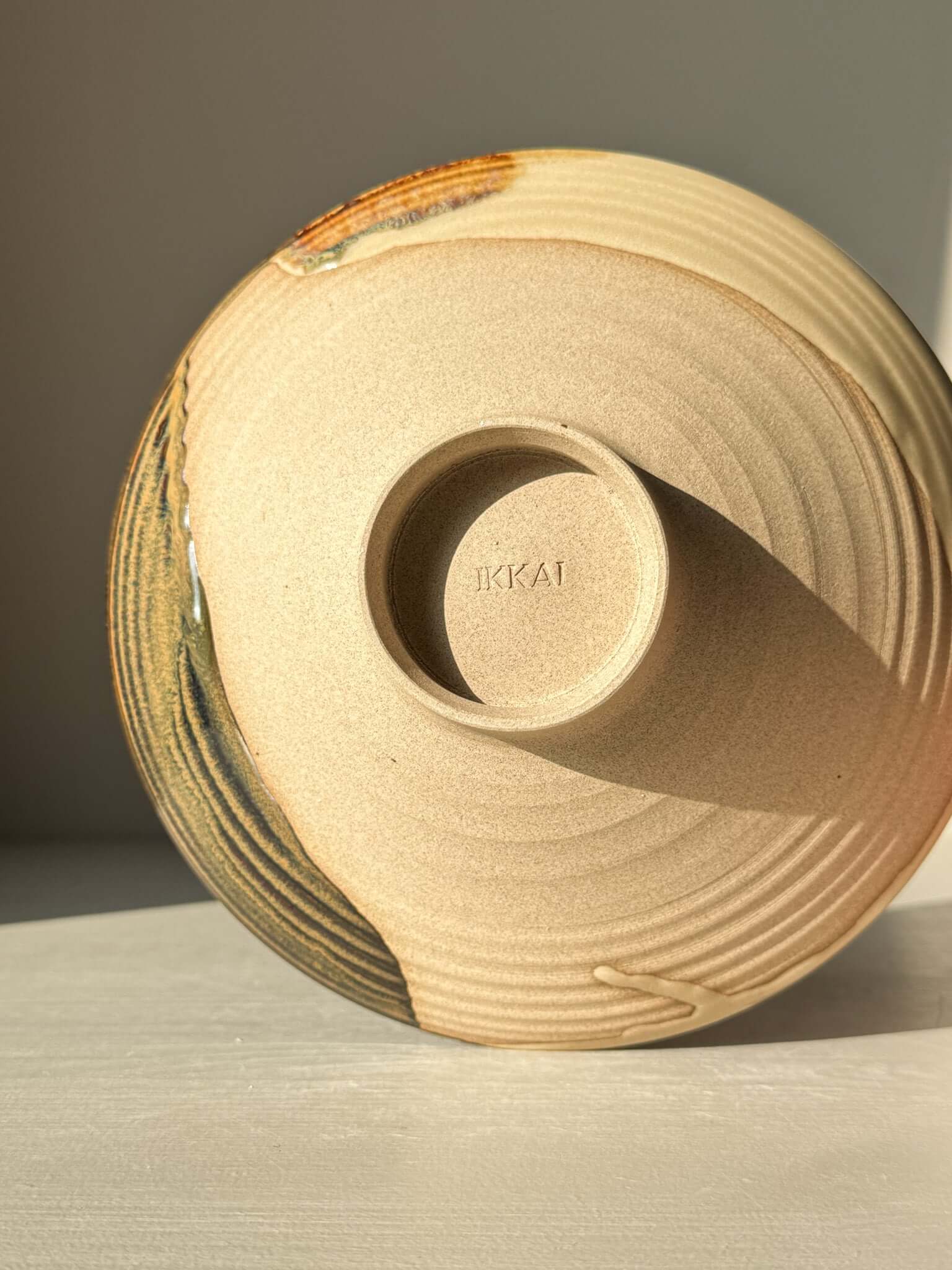 Base view of handmade ceramic Small Serving Bowl - Inyo Series #01, showcasing the unique glaze pattern and stamped base.