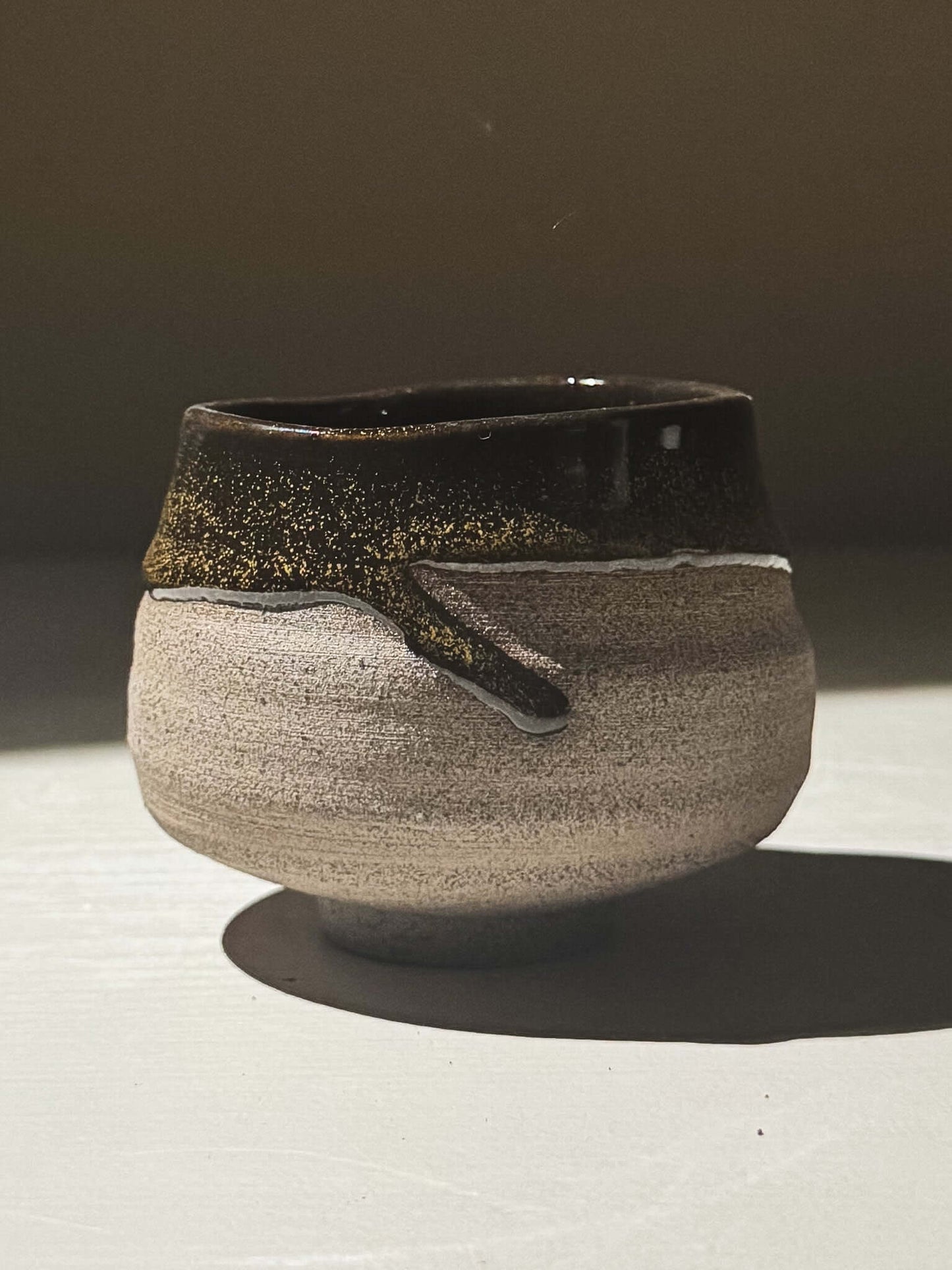 Yunomi Cup - Kuro Ash #02 featuring a glossy black glaze with golden speckles on a wheel-thrown stoneware body.