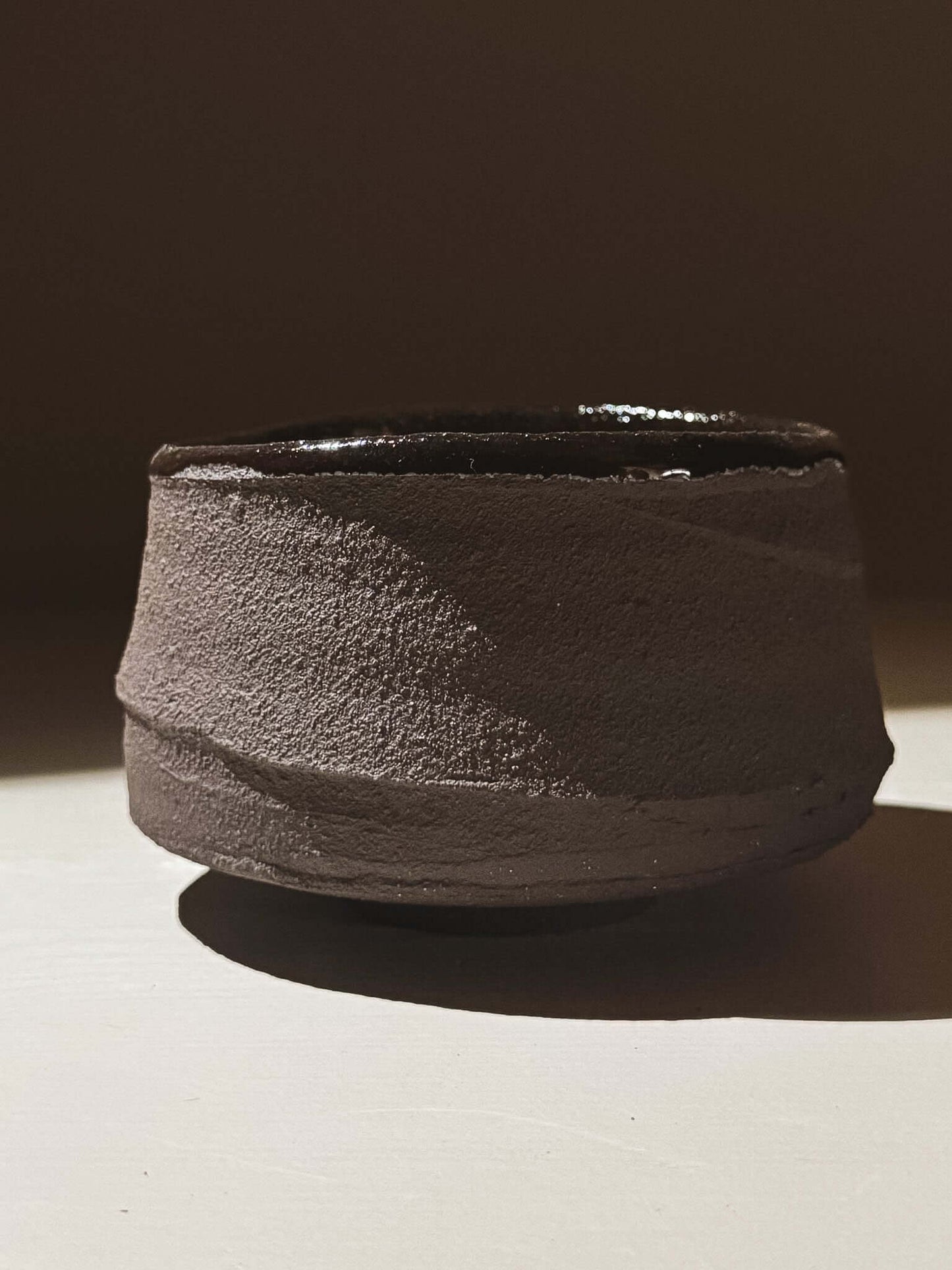 Kuro Matcha Bowl #09 with textured dark brown exterior and glossy dark interior, inspired by volcanic stone and earthy textures.