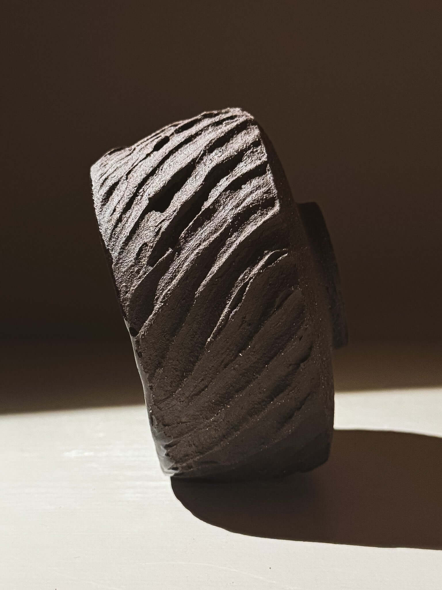 Kuro Matcha Bowl #08 with textured dark brown exterior inspired by volcanic stone, showcasing earthy textures and natural tones.