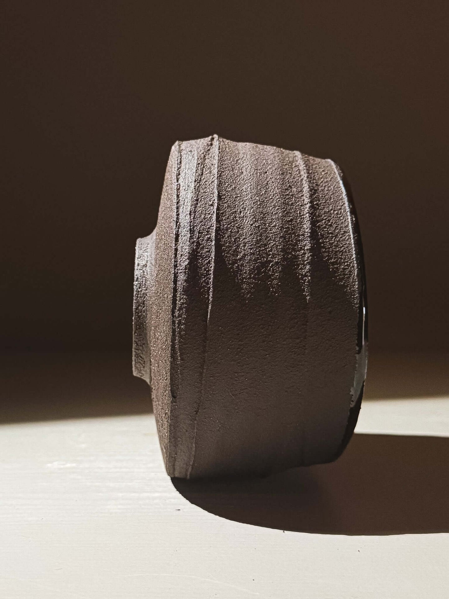 Side view of Kuro Matcha Bowl #10 with textured dark brown exterior inspired by volcanic stone.