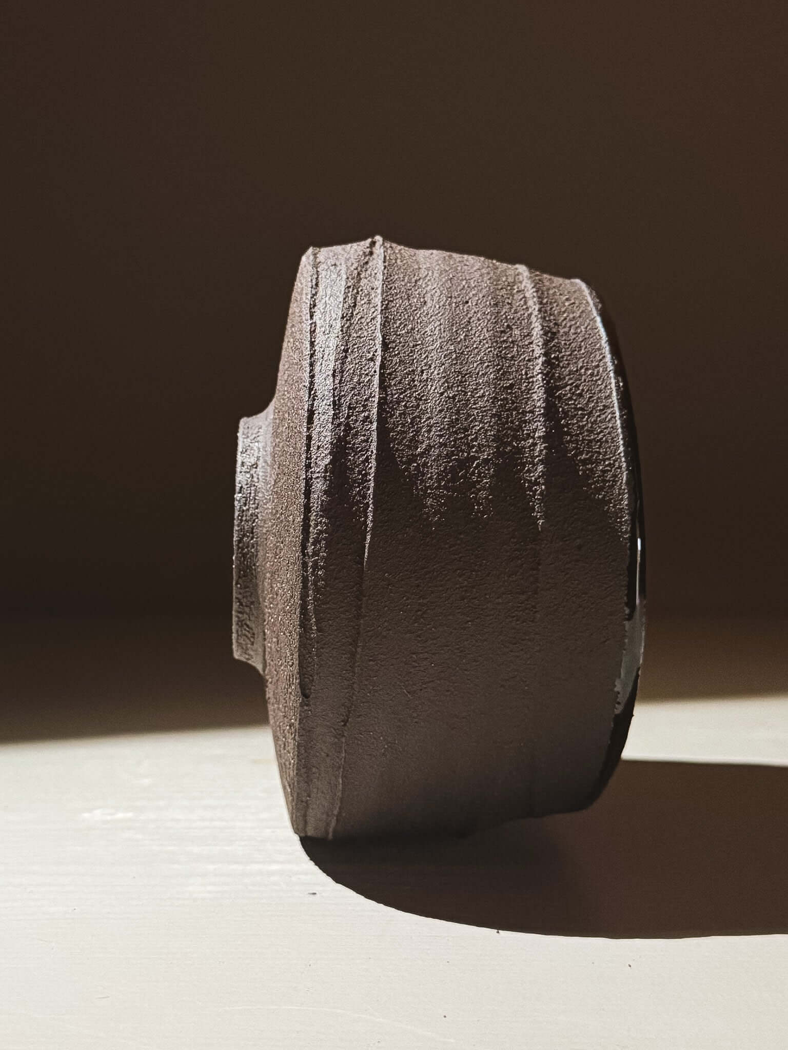 Side view of Kuro Matcha Bowl #10 with textured dark brown exterior inspired by volcanic stone.