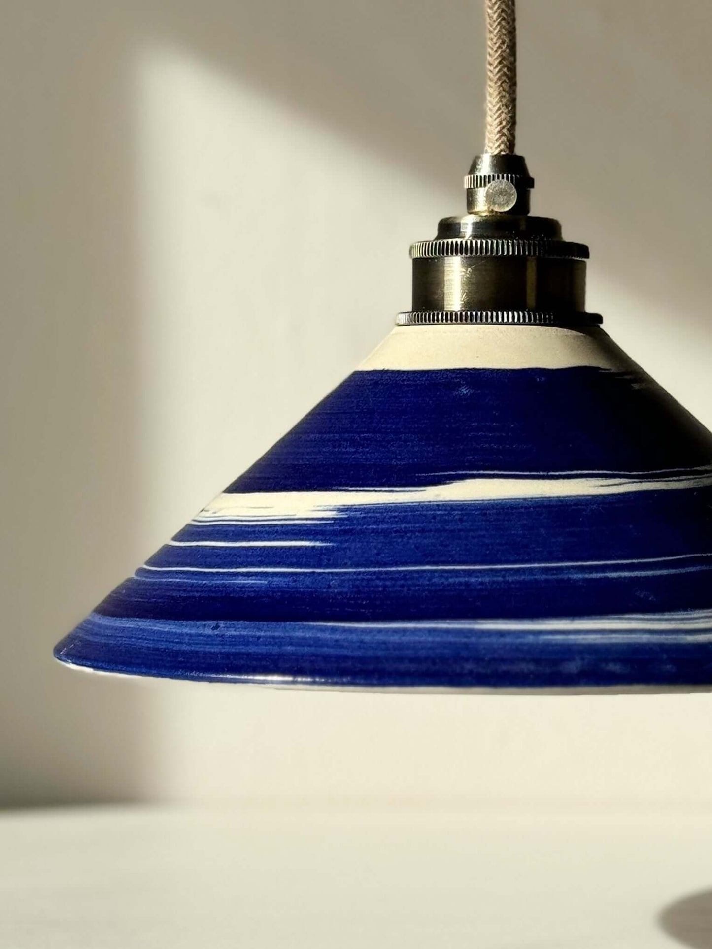 Handmade ceramic lamp shade from Gosu Series, featuring cobalt blue accents and glossy finish, highlighting artisanal craftsmanship.