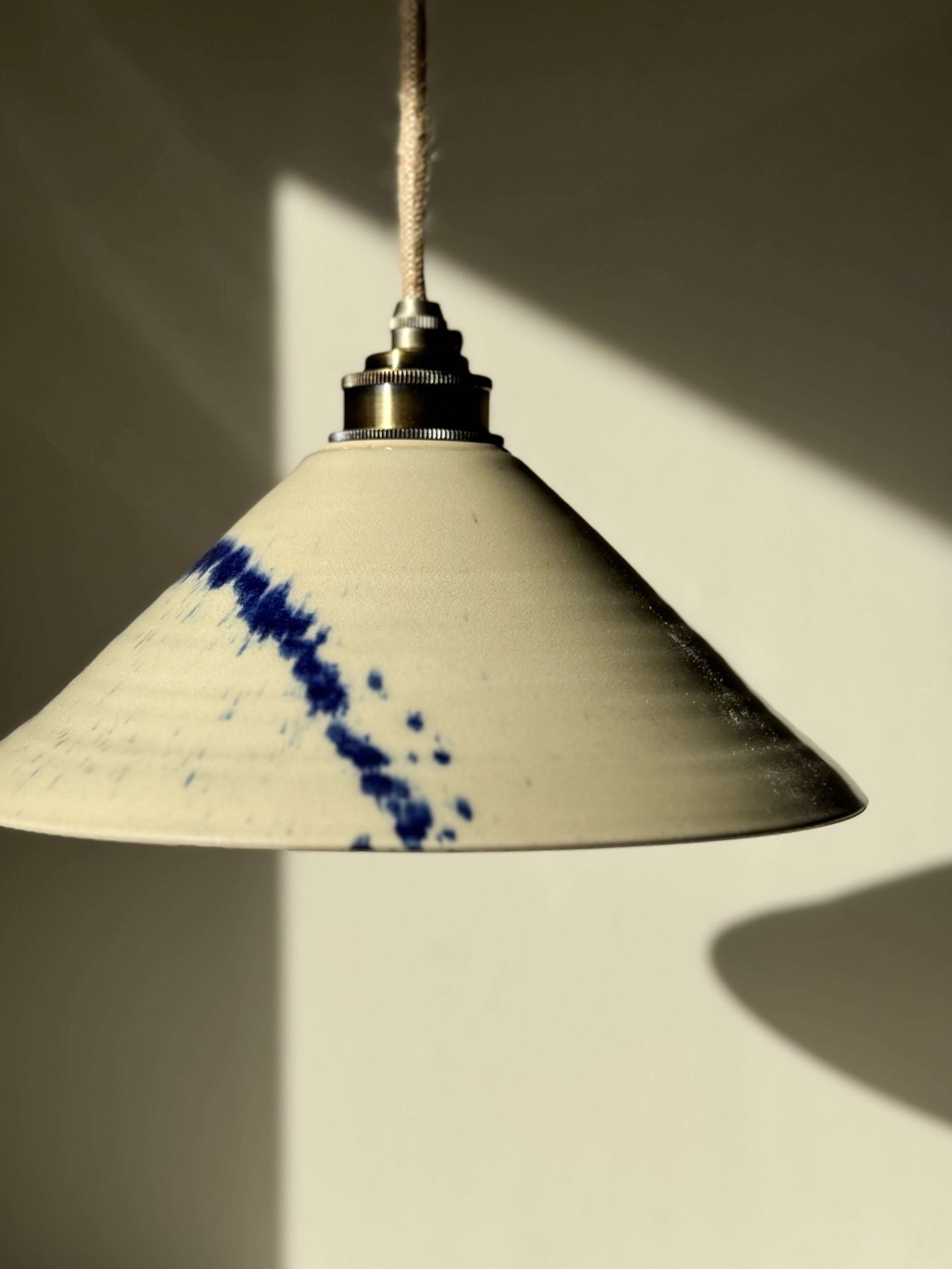 Handmade ceramic lamp shade from the Gosu Series with cobalt blue accents, showcasing unique hand-splashed design and glossy finish.