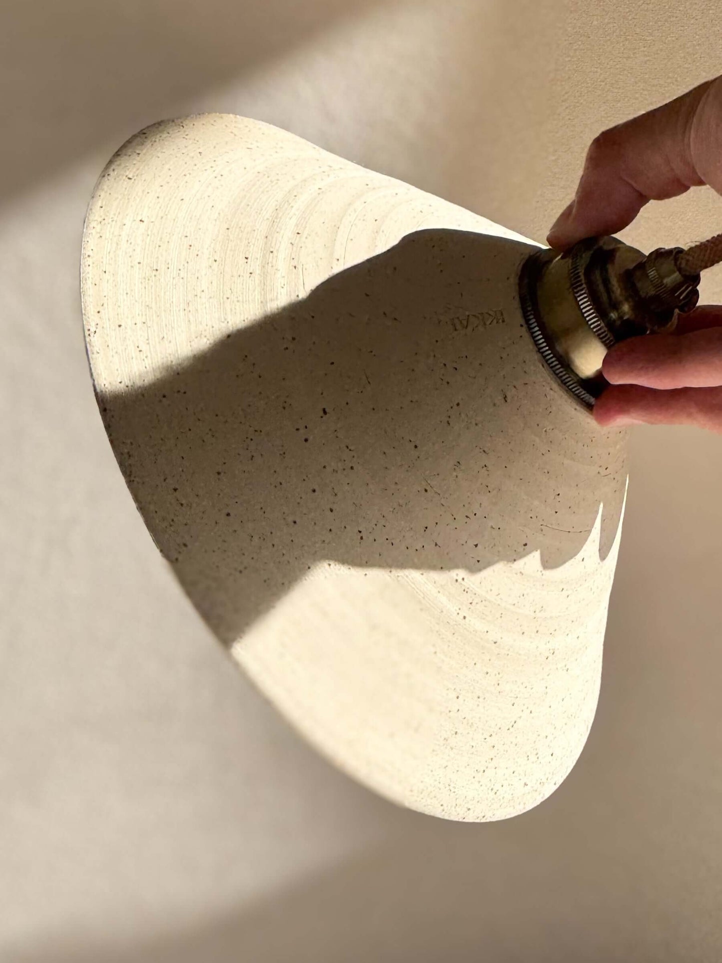 Handmade ceramic lamp shade installed, showcasing the half clear glaze interior and raw matte exterior.