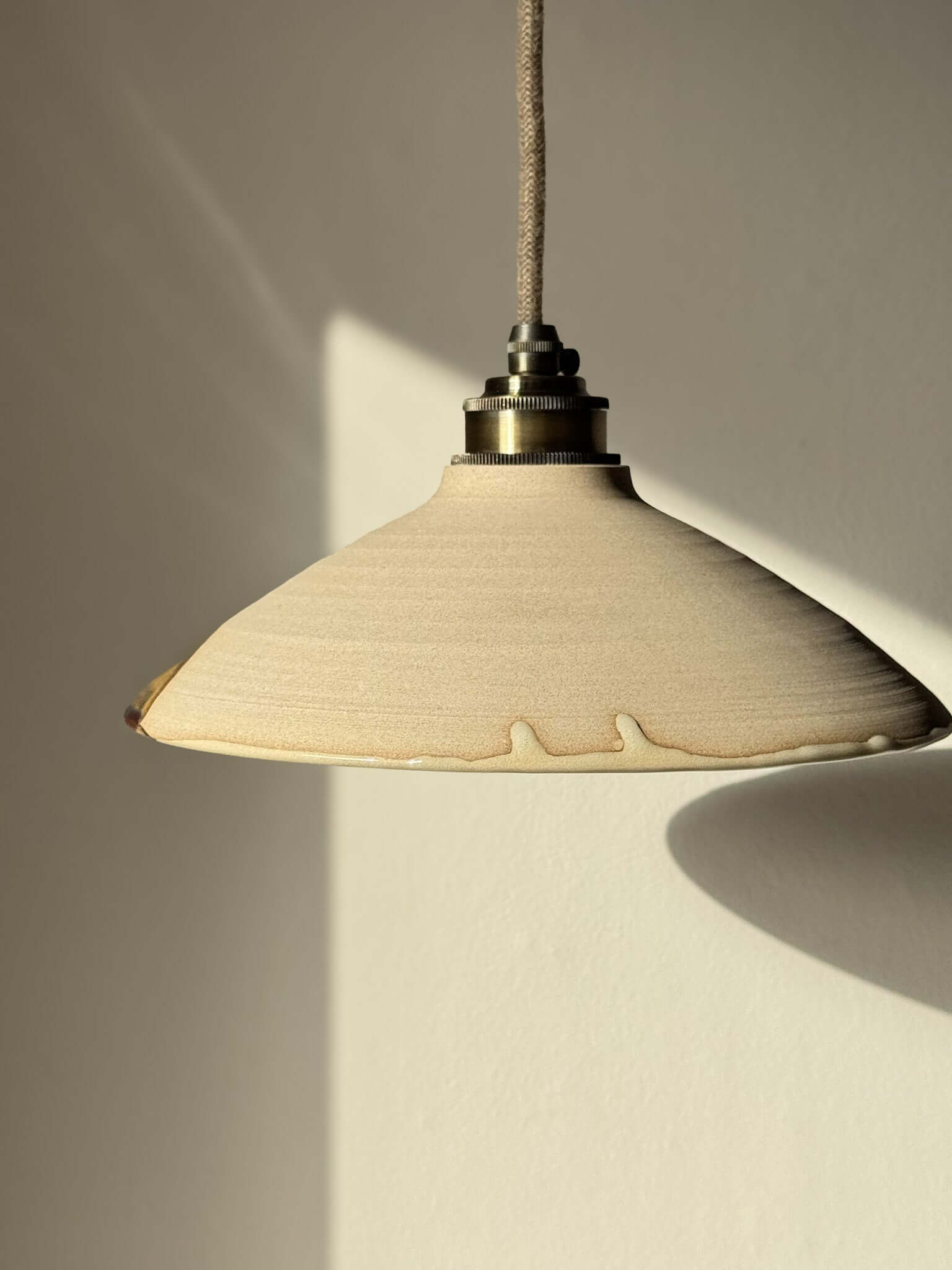 Ceramic Lamp Shade – Inyo #02, handmade ceramic with raw clay texture and glossy glaze highlighting bronze and amber tones.